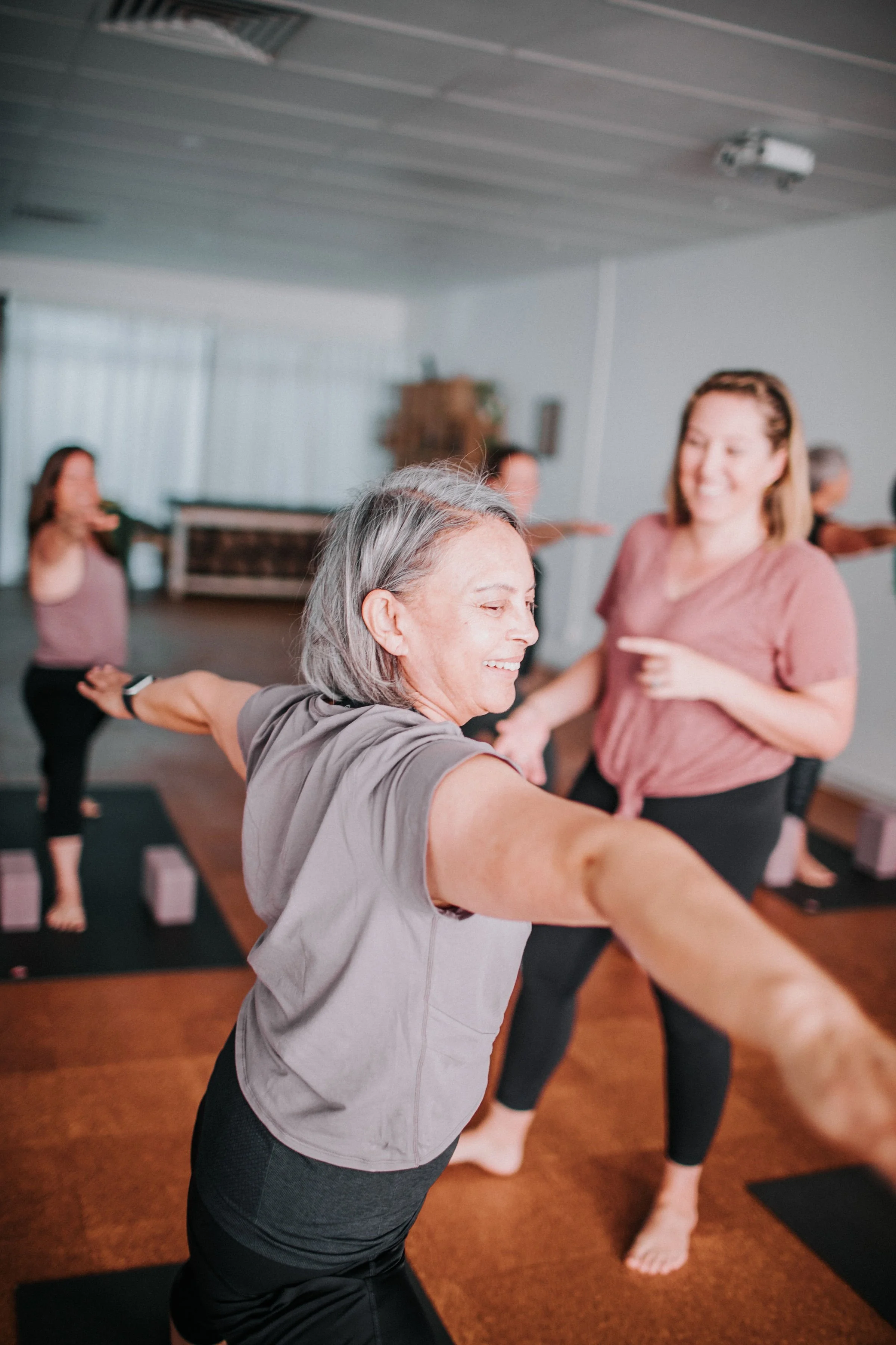 Senior Teaching guiding a group of women in a boutique Perth yoga studio