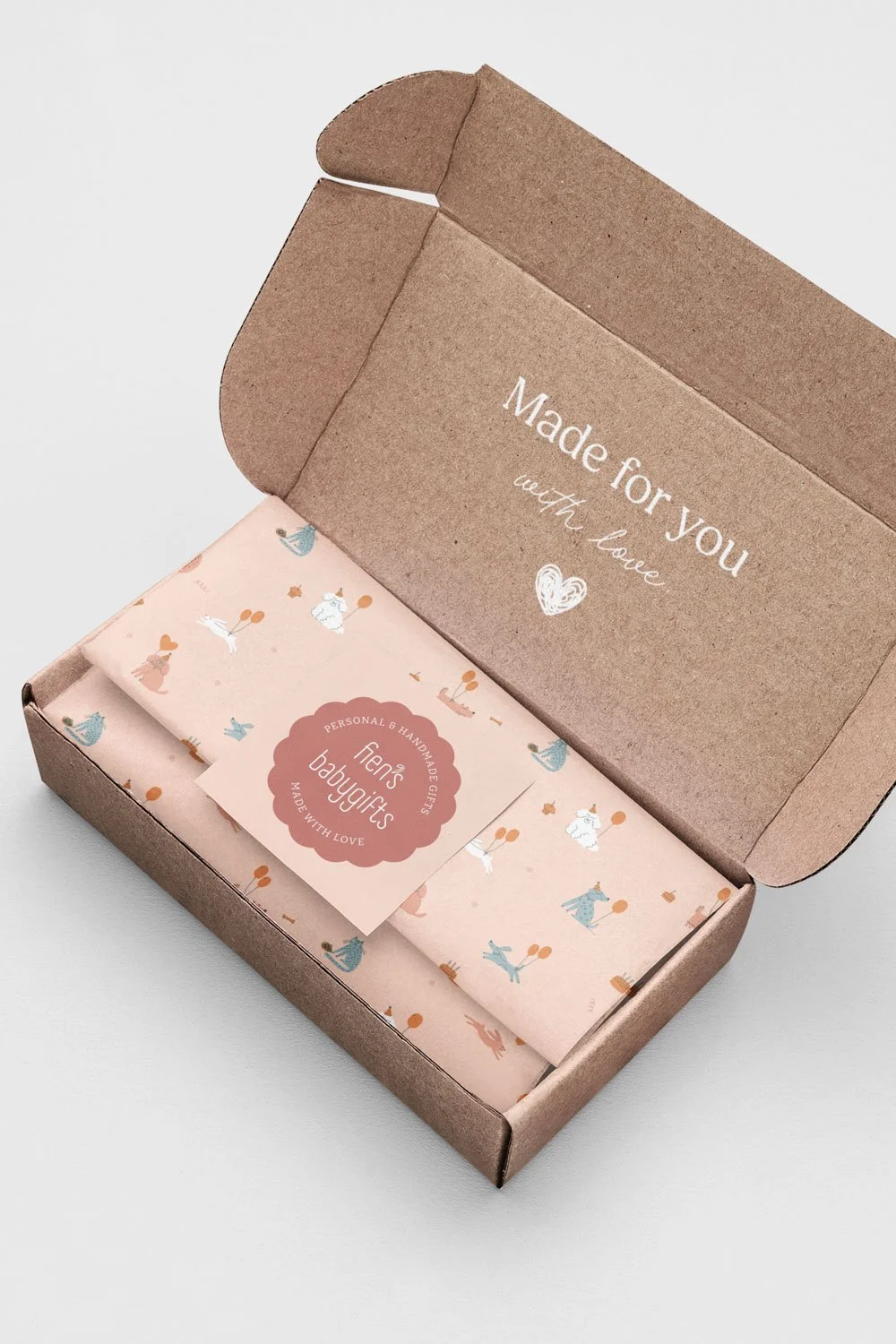 Verpakking en logo ontwerp voor Fien's Babygifts webshop, met feestelijke honden katten en konijnen op het inpakpapier