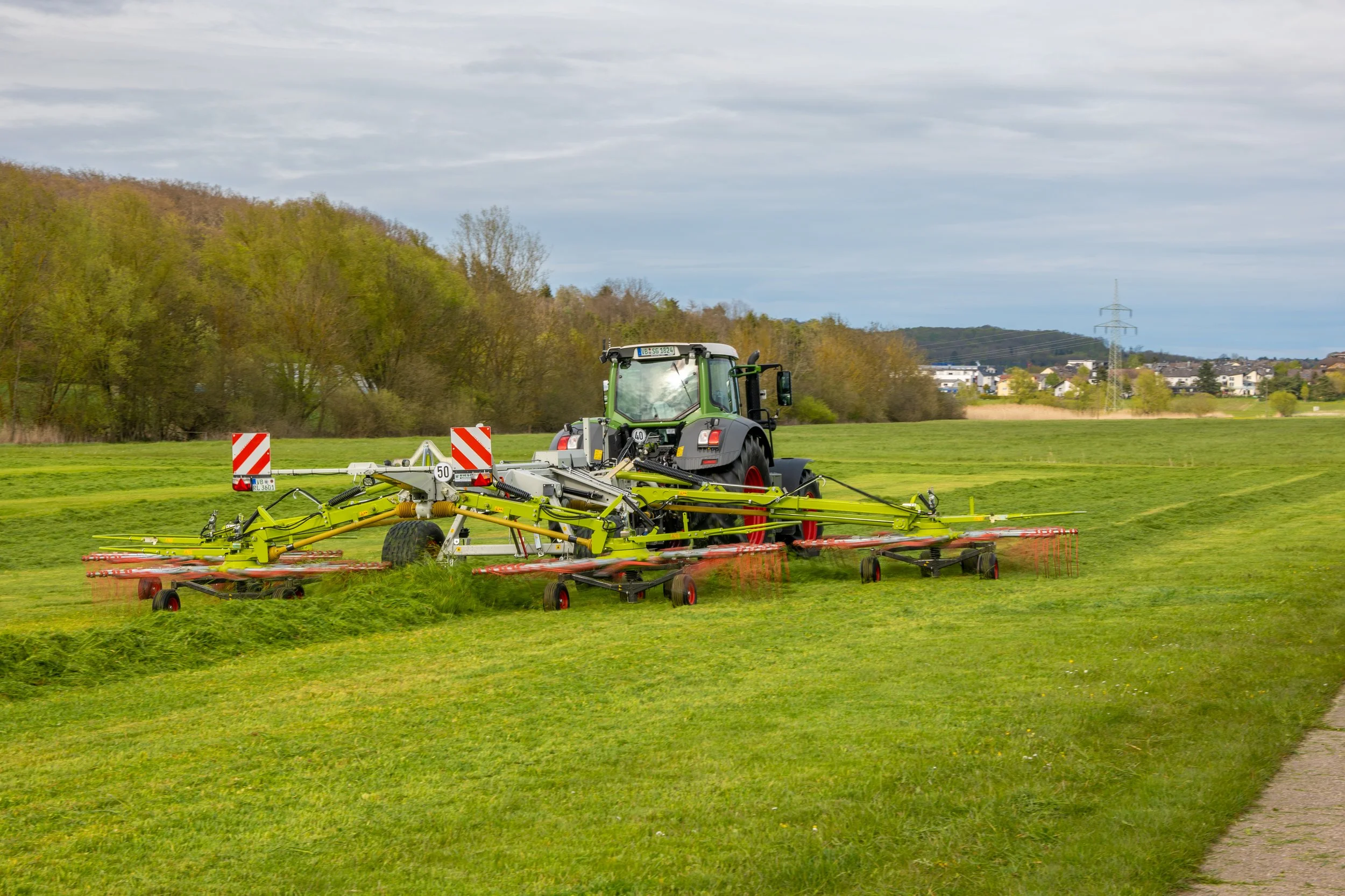 Traktor bei der Heuernte auf einem Feld