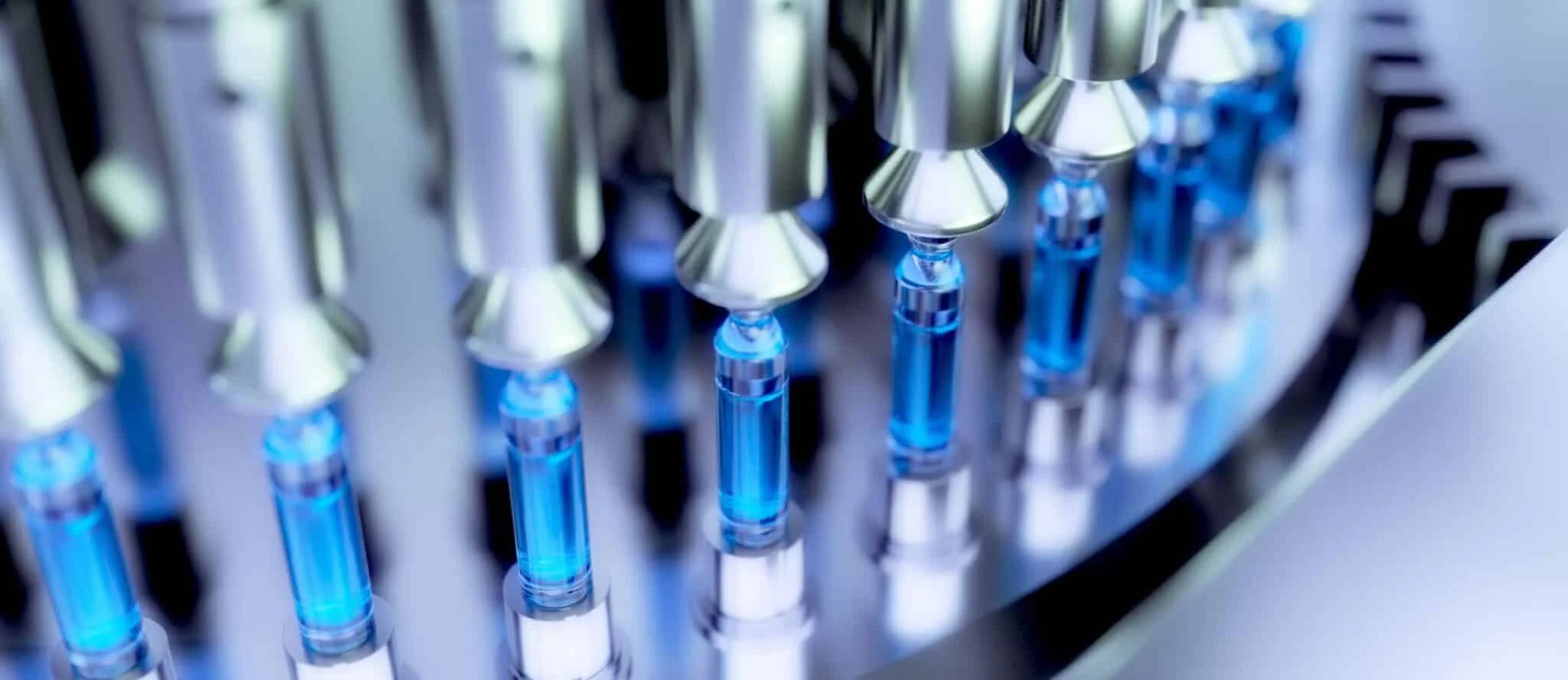 Produzione automatizzata di flaconi medici con liquido blu.