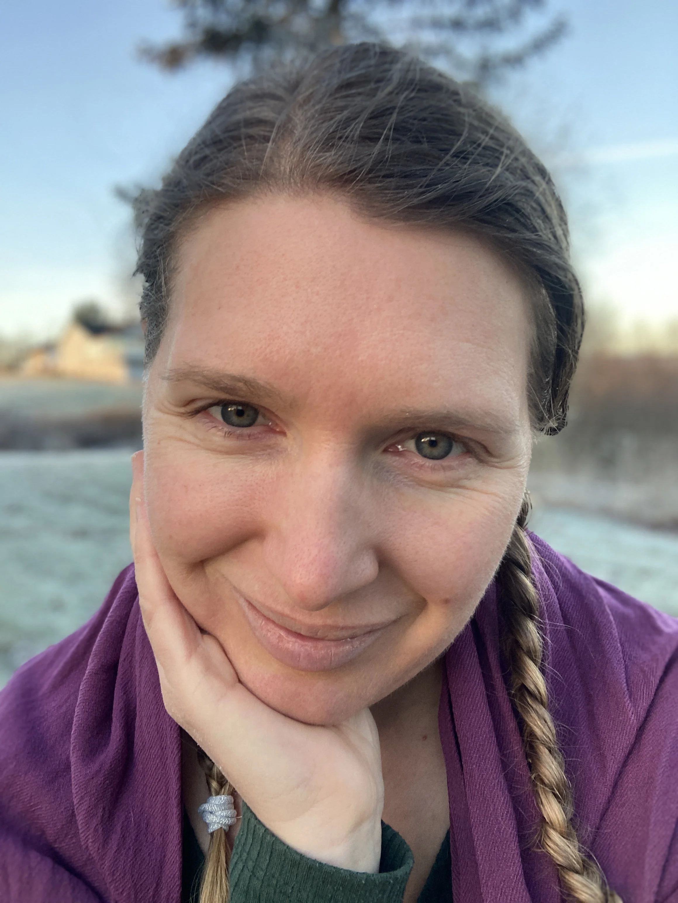 Kvinne som er ute og smiler lurt. Hun har innsett at hun ikke var dum på skolen, men at hun er nevrodivergent og lærer på en annen måte.