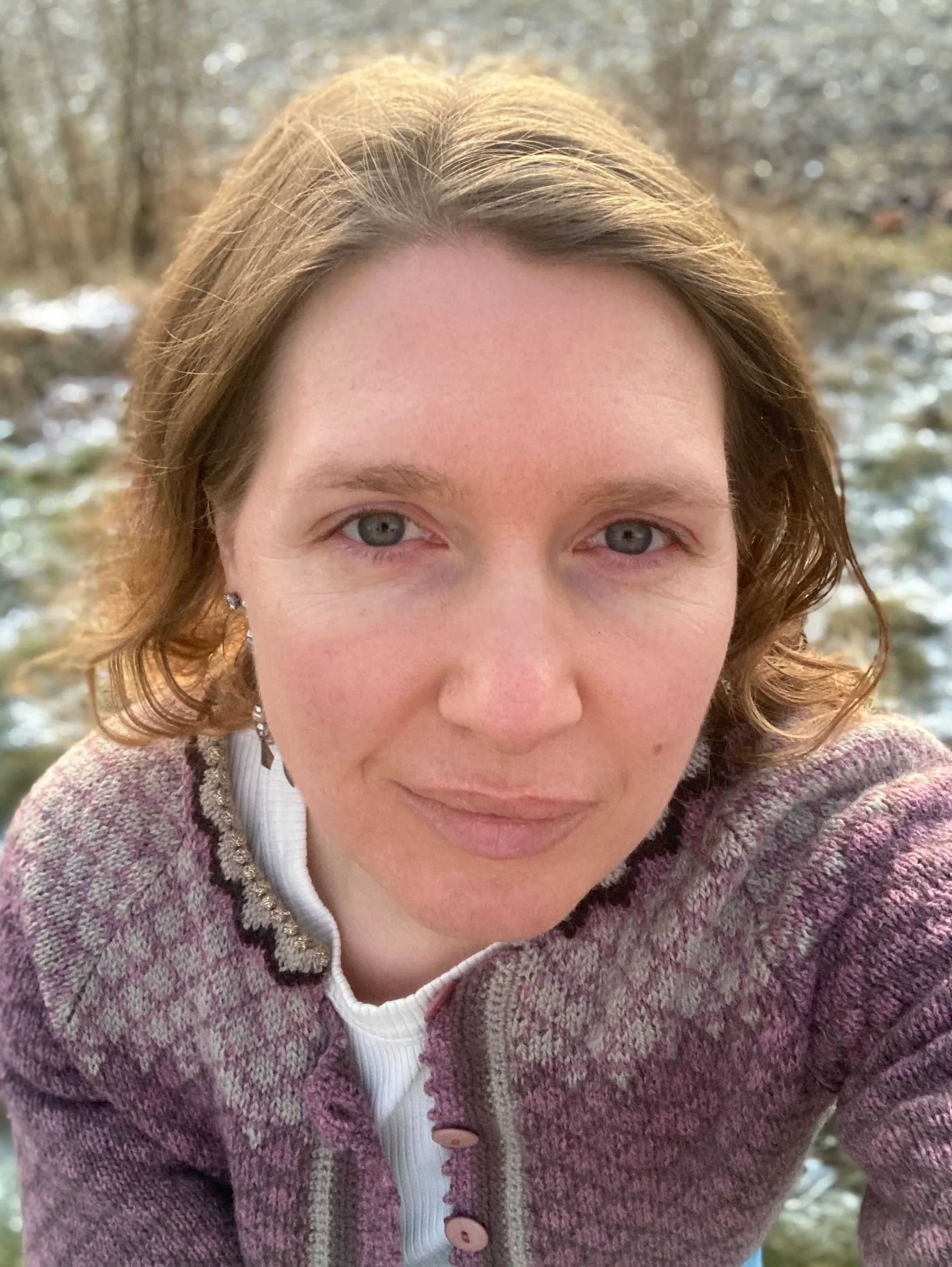 En kvinne som prøver å smile. Hun har blitt testa i livet og øver seg på å finne tilbake til seg selv.