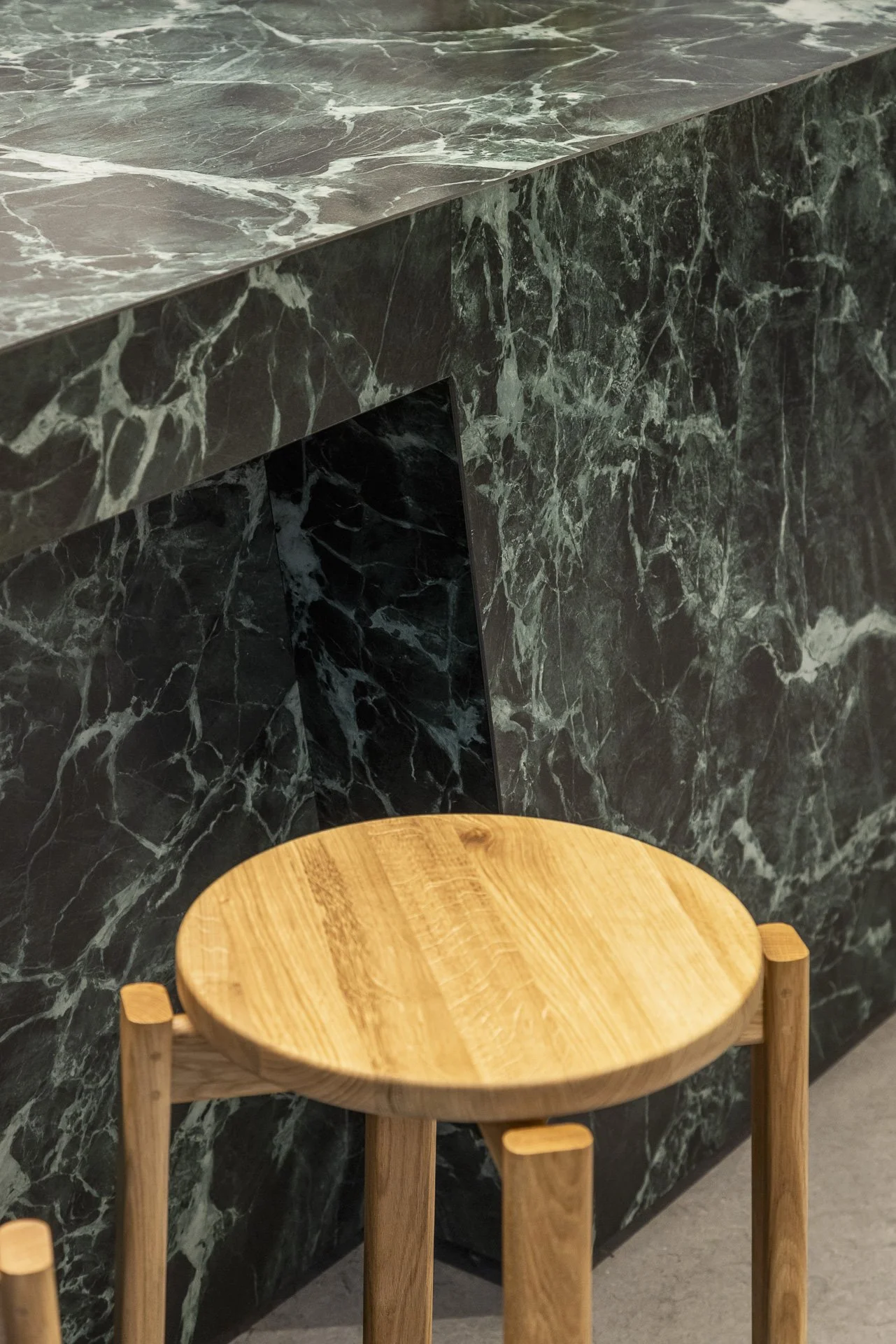 Holzhocker vor Tisch mit Marmor