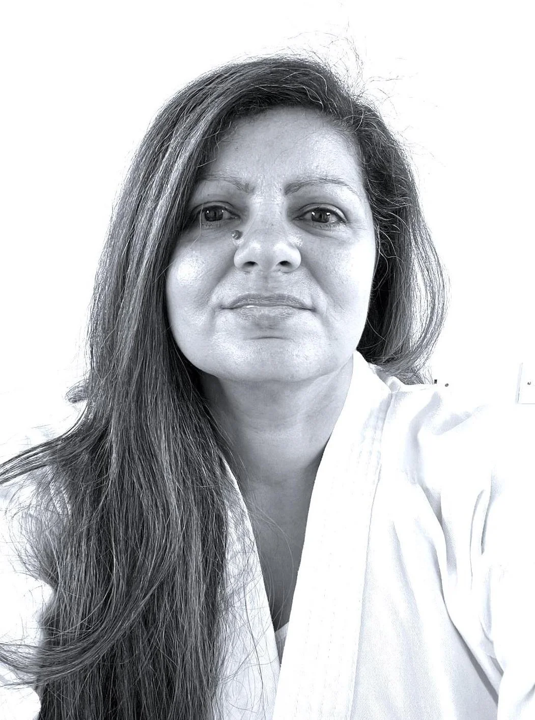Black and white portrait of a woman with long hair wearing a white uniform, looking at the camera with a neutral expression.