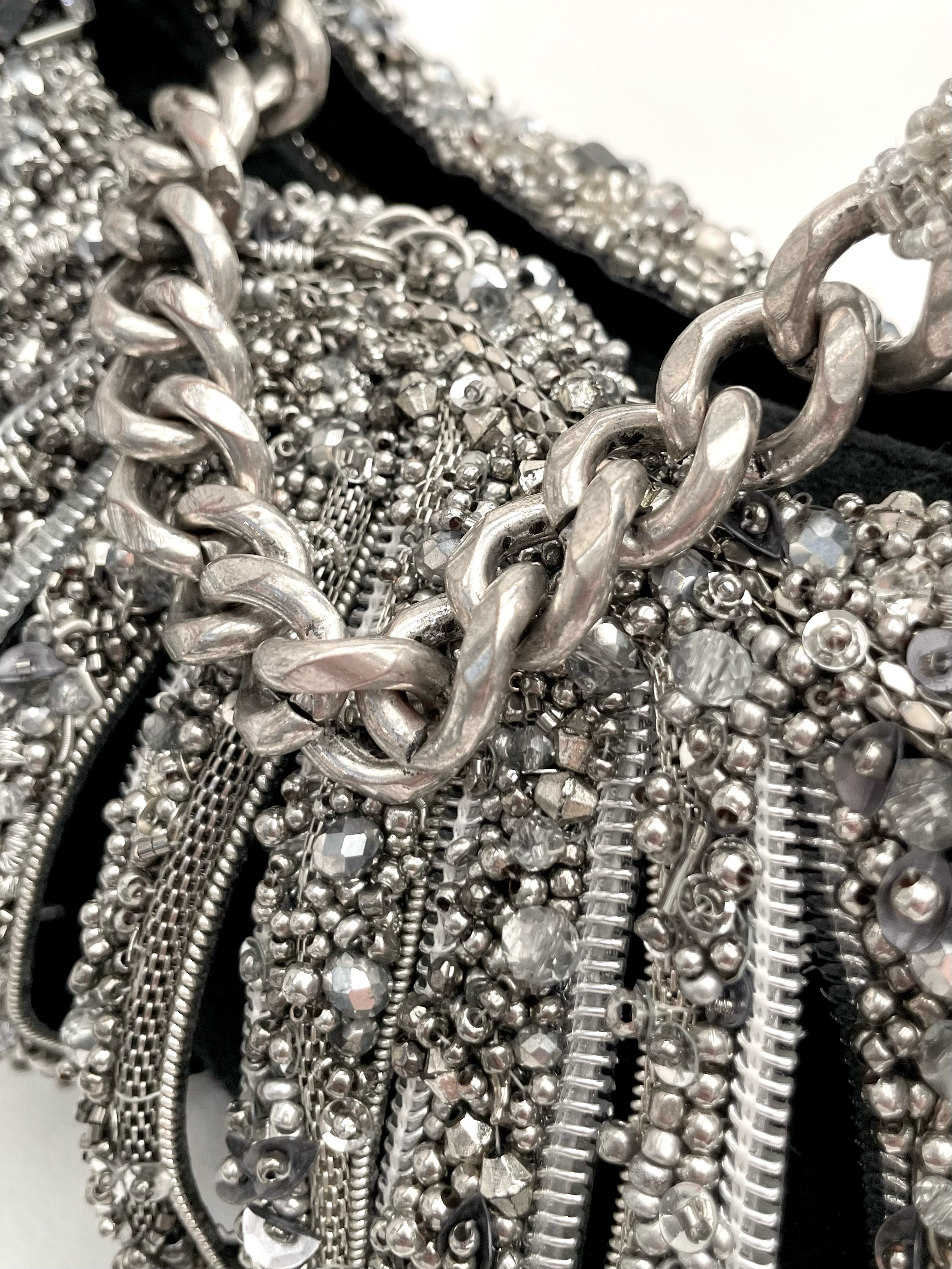 Close-up of various silver jewelry chains and bracelets with different textures and sizes