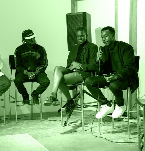 Man speaks in front of the crowd at Afrikaleidoscope Art Exhibit