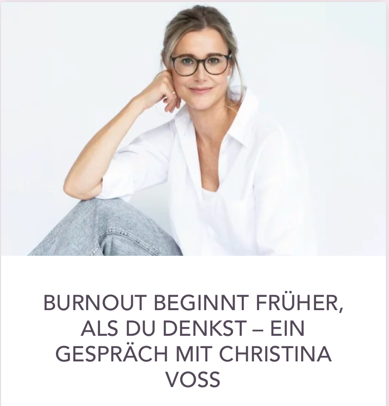 Ein Porträt von Christina Voss, die lächelnd in die Kamera schaut, sitzend vor einem weißen Hintergrund.