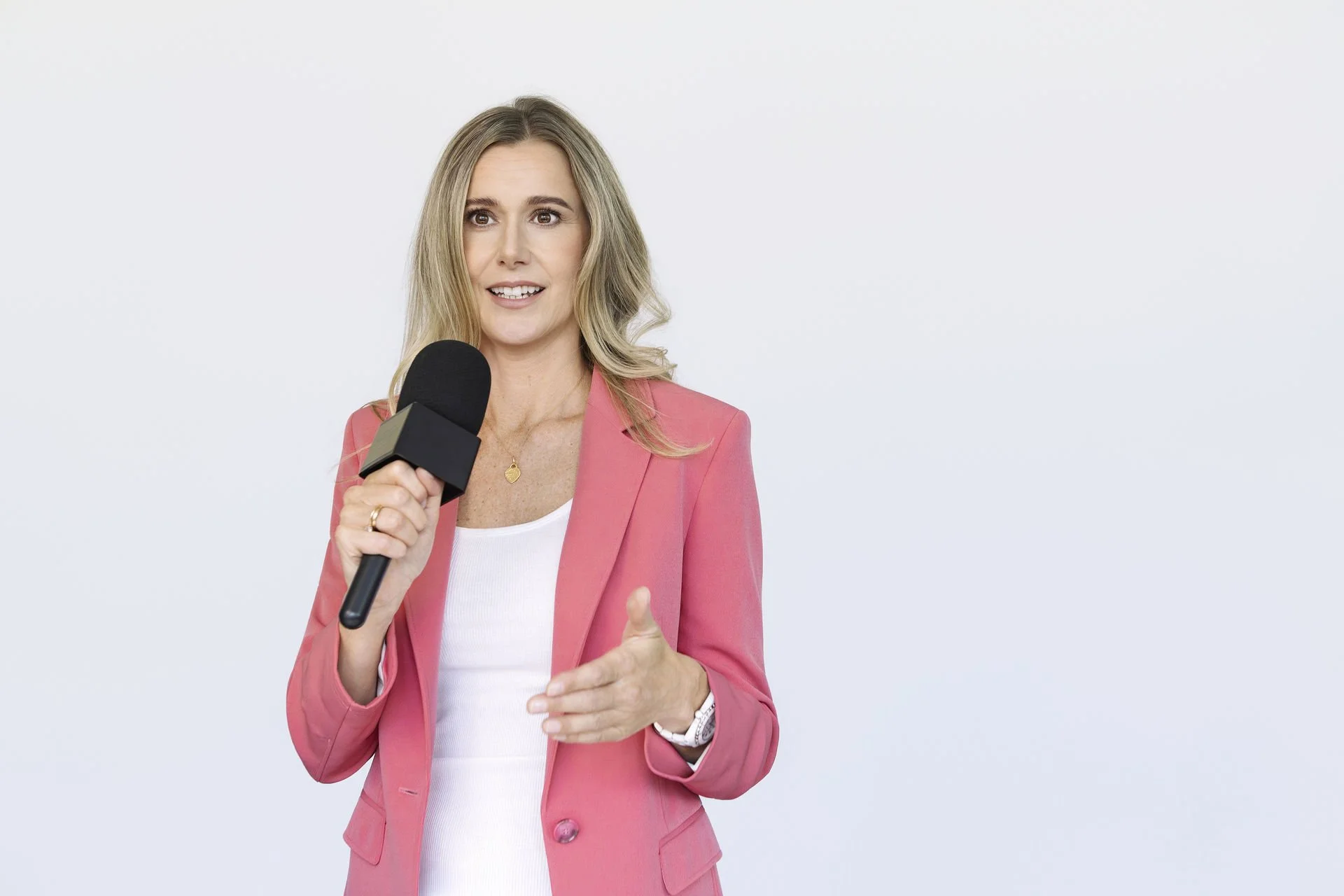 Christina Voss hält ein Mikrofon in der Hand und hält einen Vortrag über Burnout Präventation.