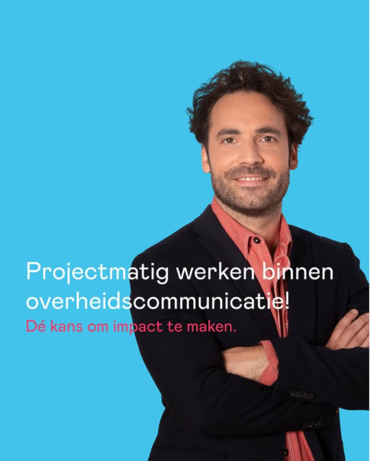A smiling man with dark, curly hair and a beard, wearing a dark blazer and a red shirt, standing with arms crossed against a bright blue background, with Dutch text overlay.