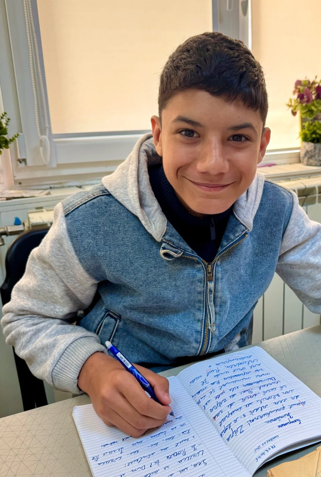 Boy at Delia's Center writing a letter to his pen pal
