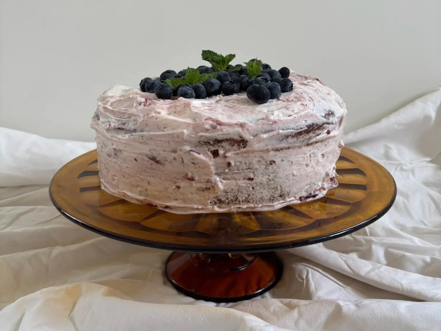 Huisgemaakte blauwe-bessencake op taartenstandaard bij brunchcatering van Leijen & Leijen
