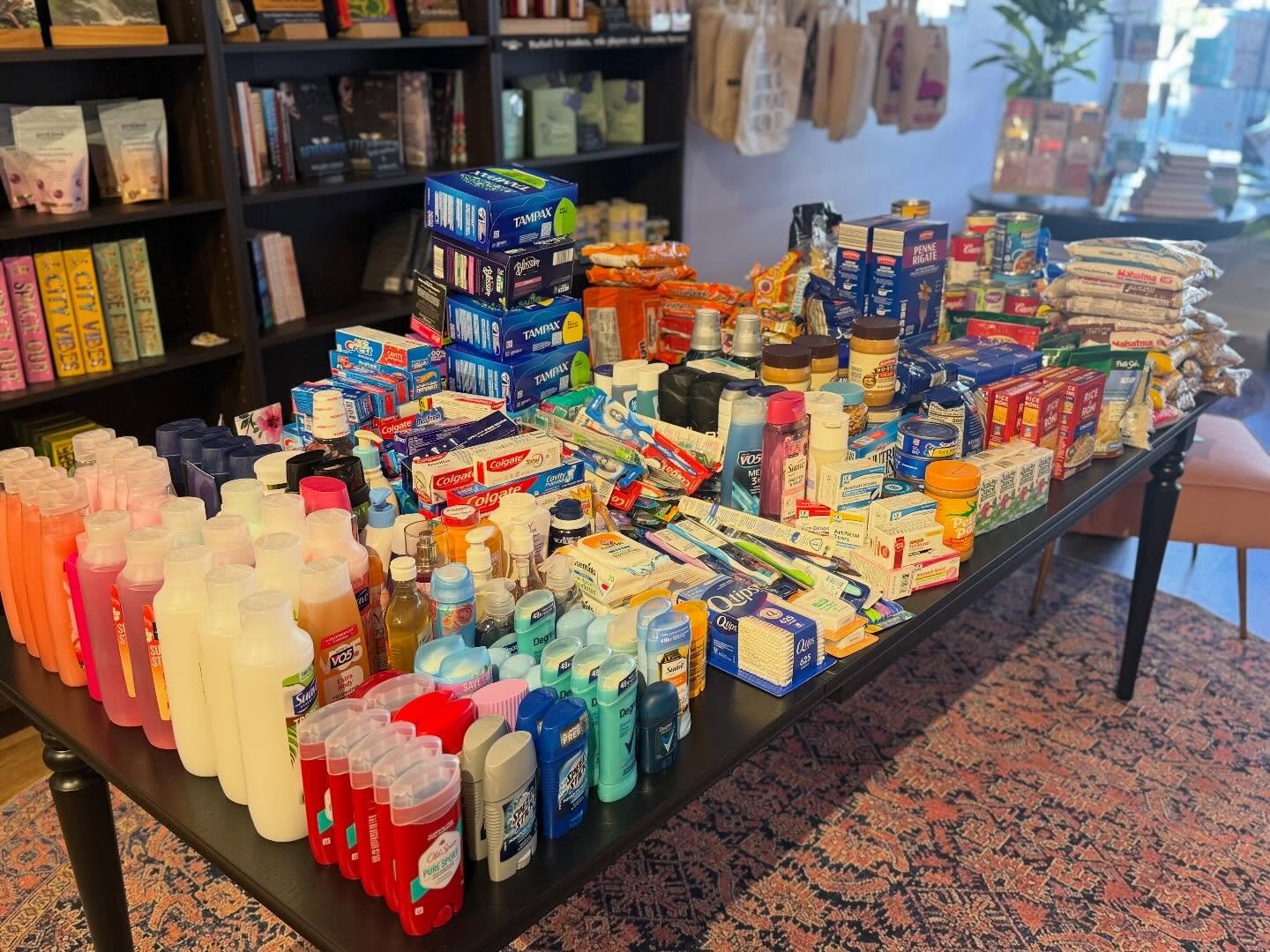 Thank y&rsquo;all for demonstrating what community is truly all about 🧡 This is just what fits on the table, by the way. At our grand opening, you showed up with bags filled to the brim with personal care items, canned goods and dry goods, all for d