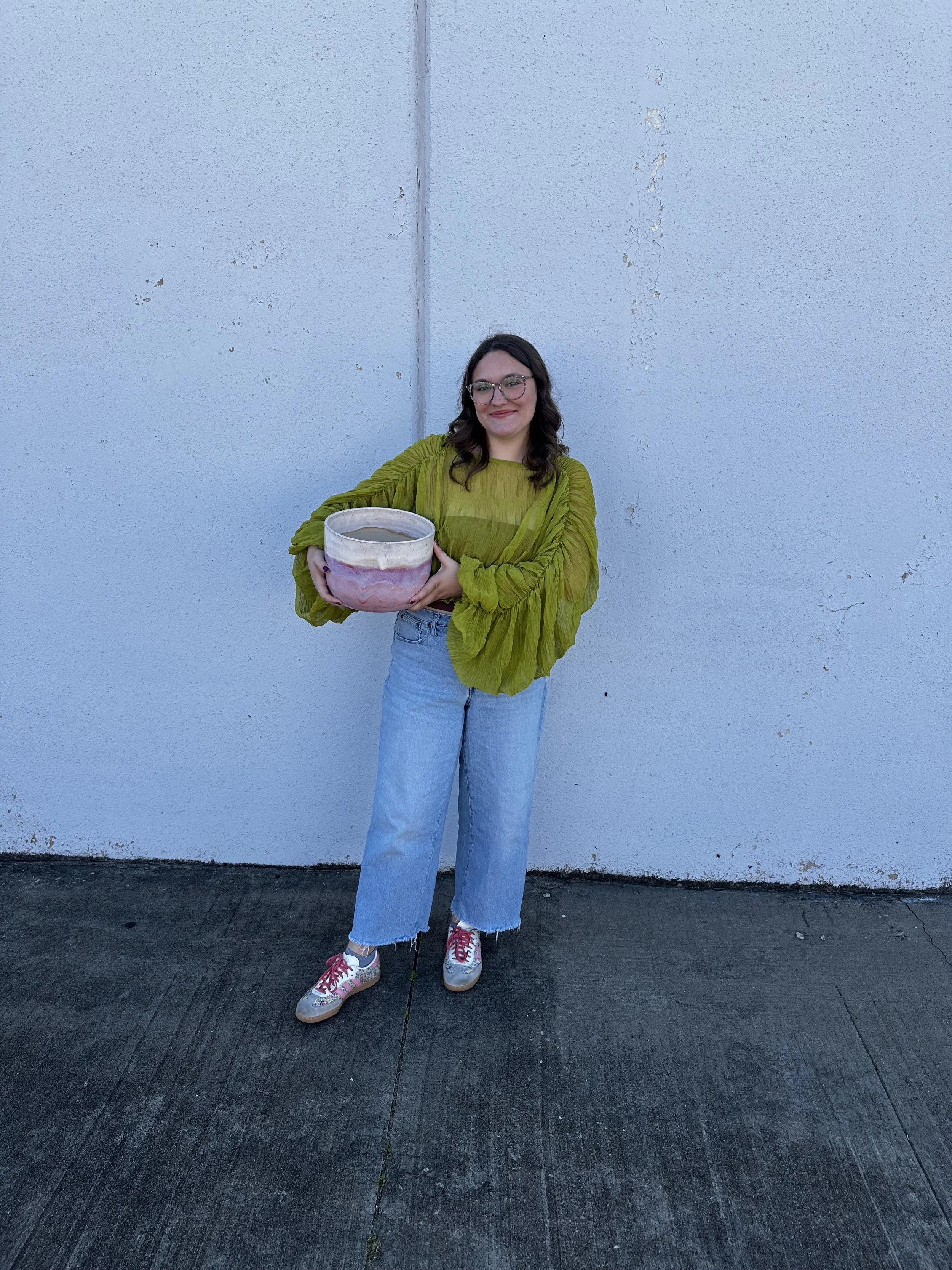 Esther holding a pink and white ceramic pot