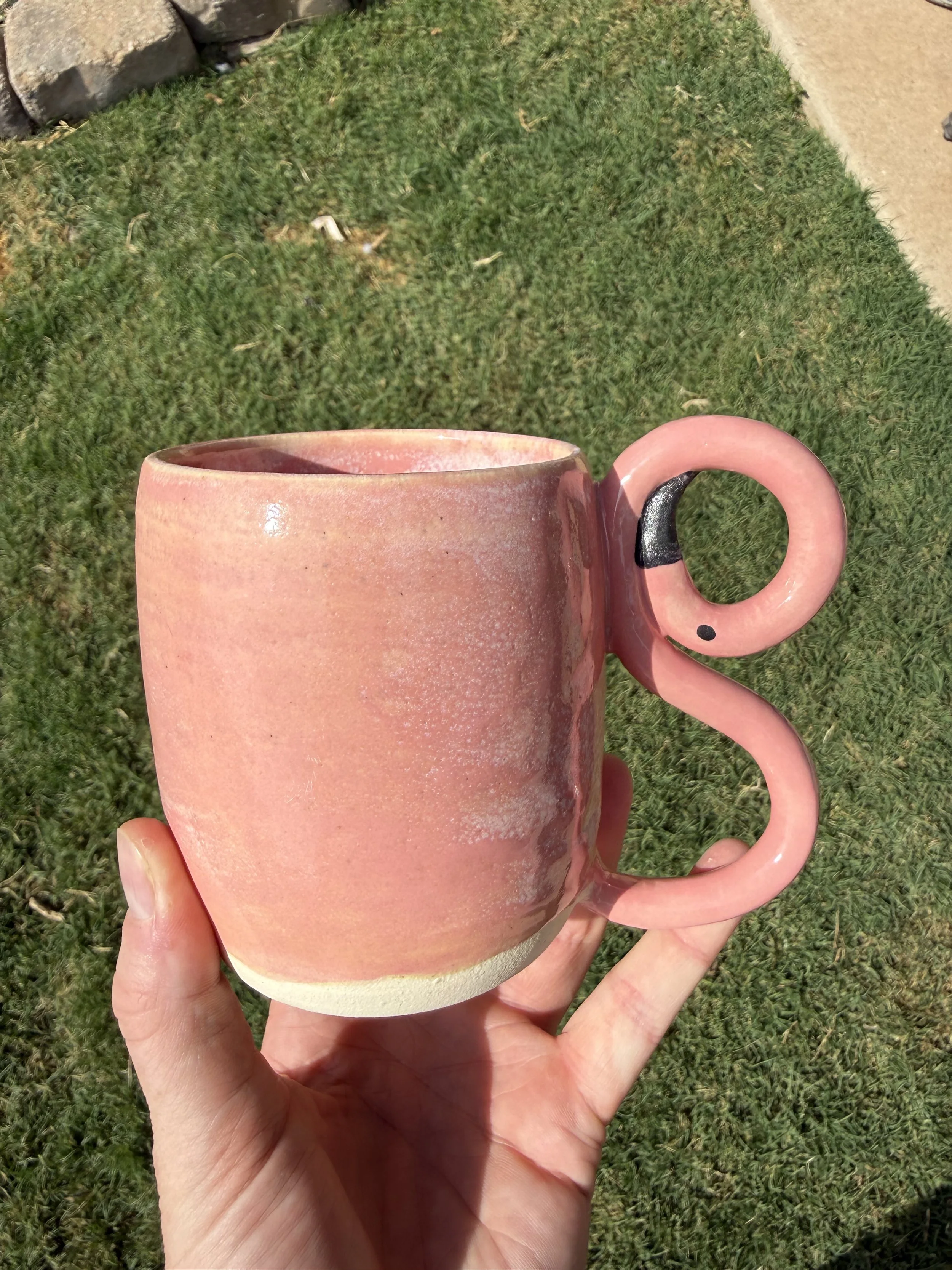 Pink cereamic mug with a flamigo-shaped handle