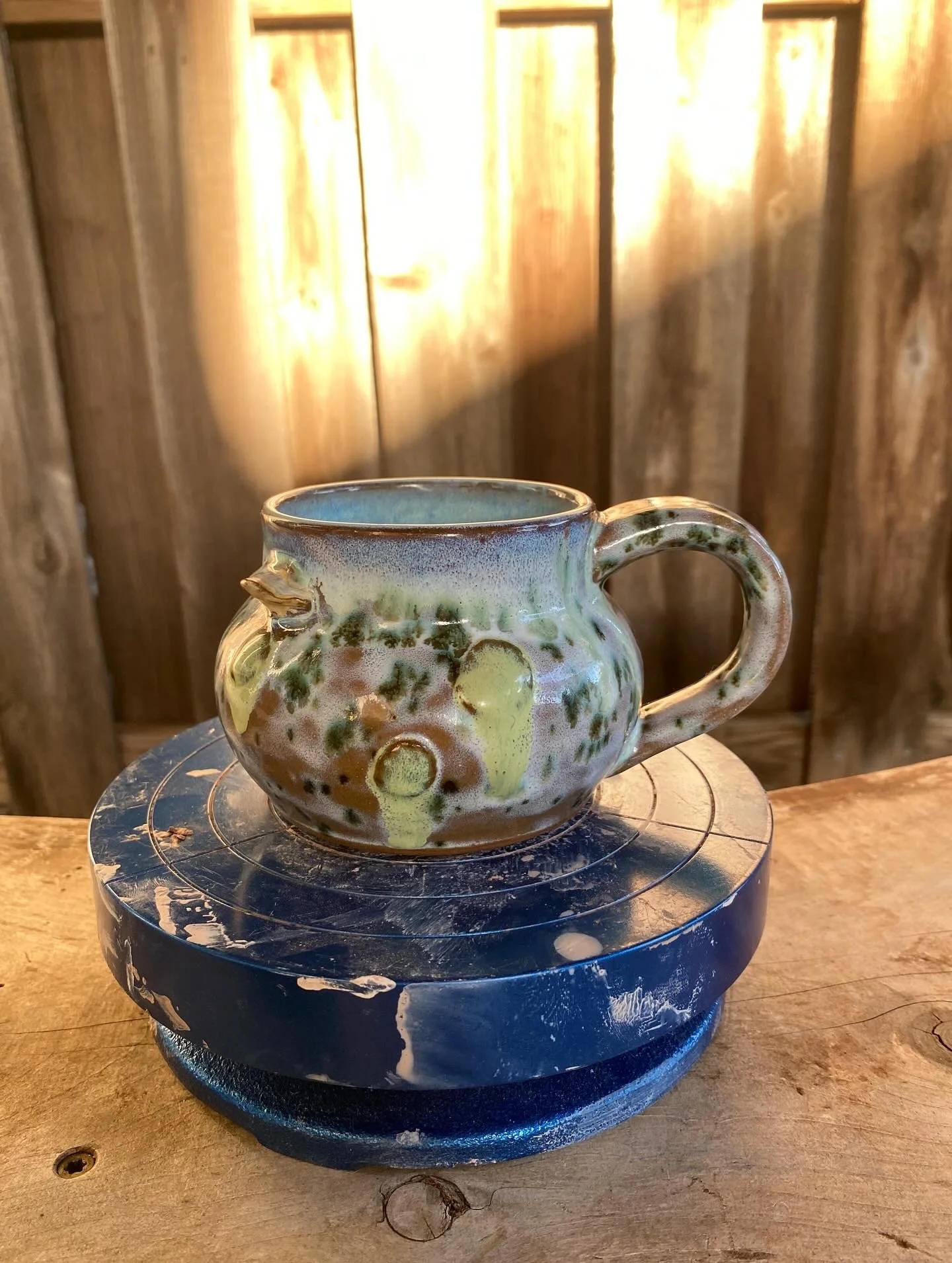 Multi-colored ceramic mug with a beak
