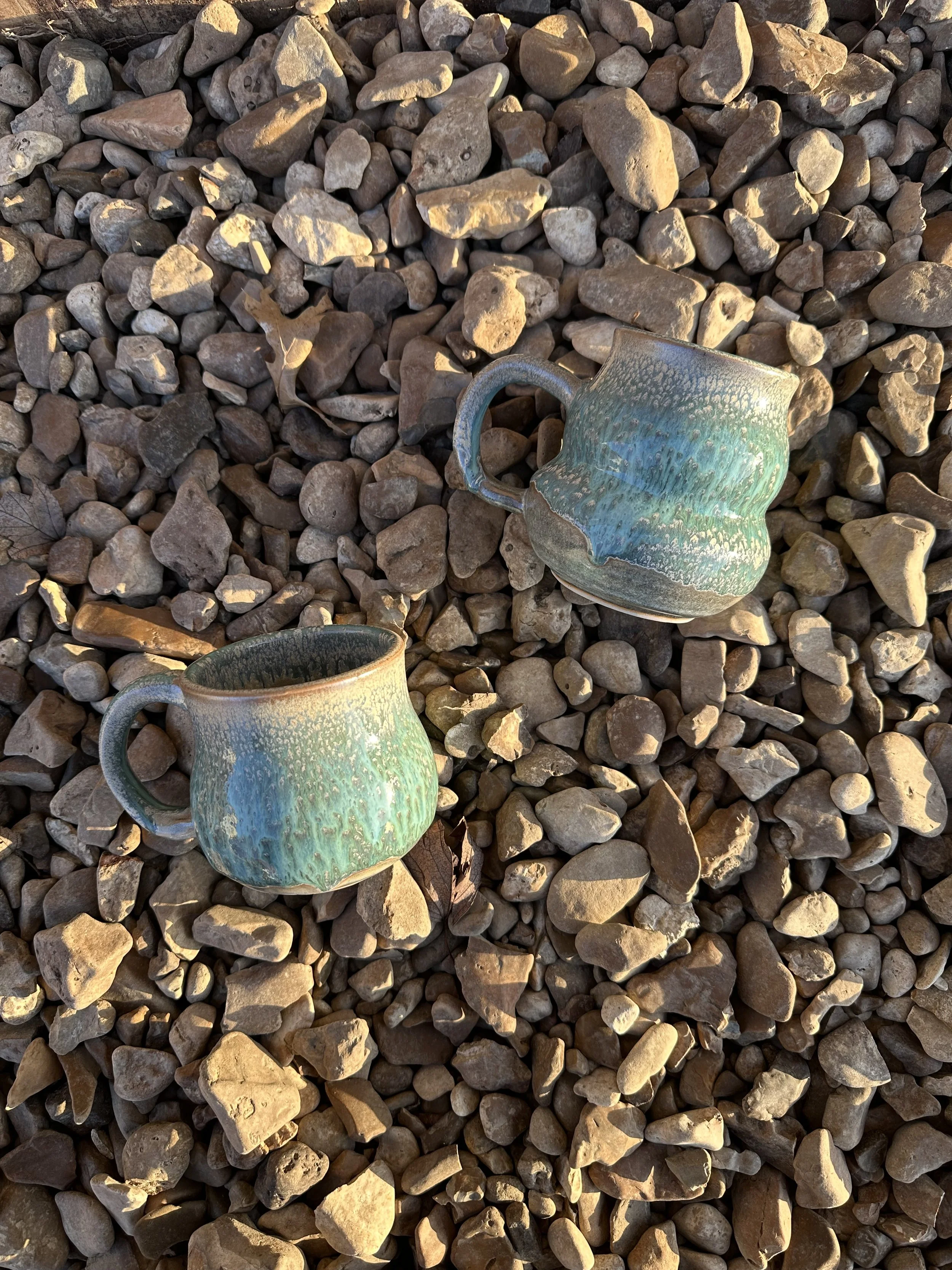 Two ceramic mugs in a runny blue-green-brown glaze