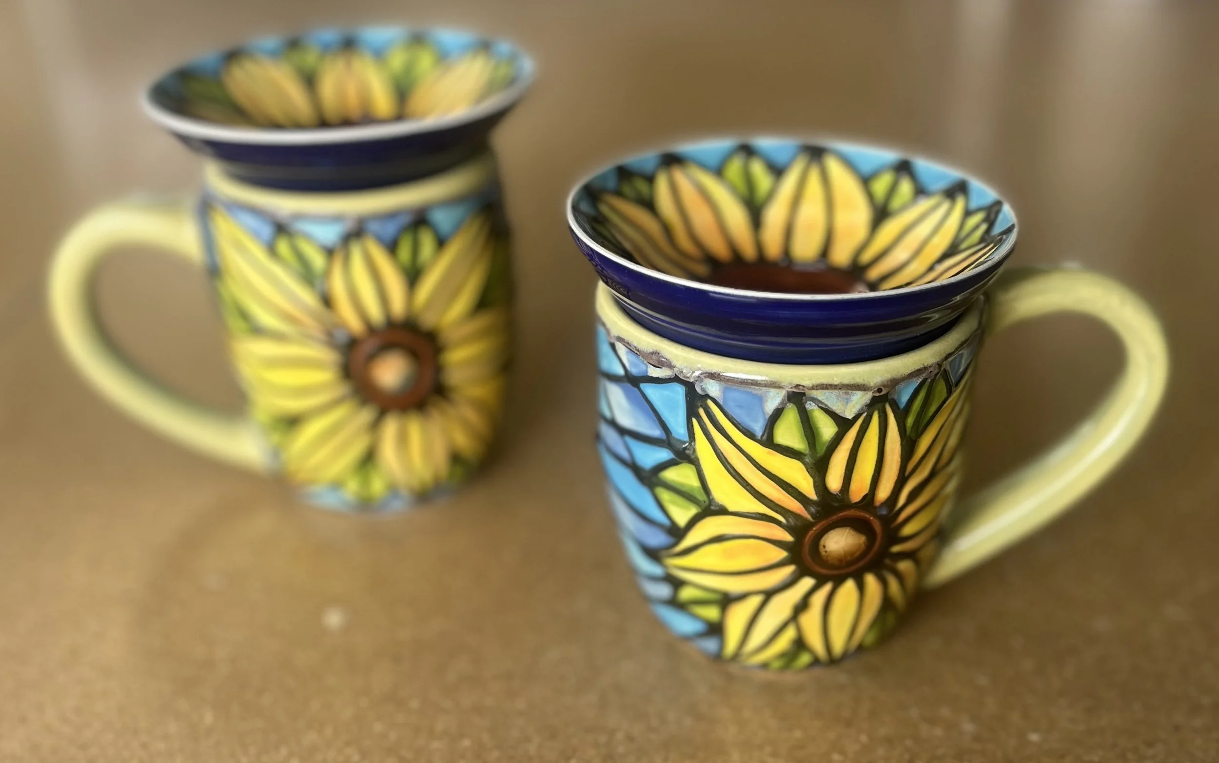 two ceramic mugs with bright sunflower designs