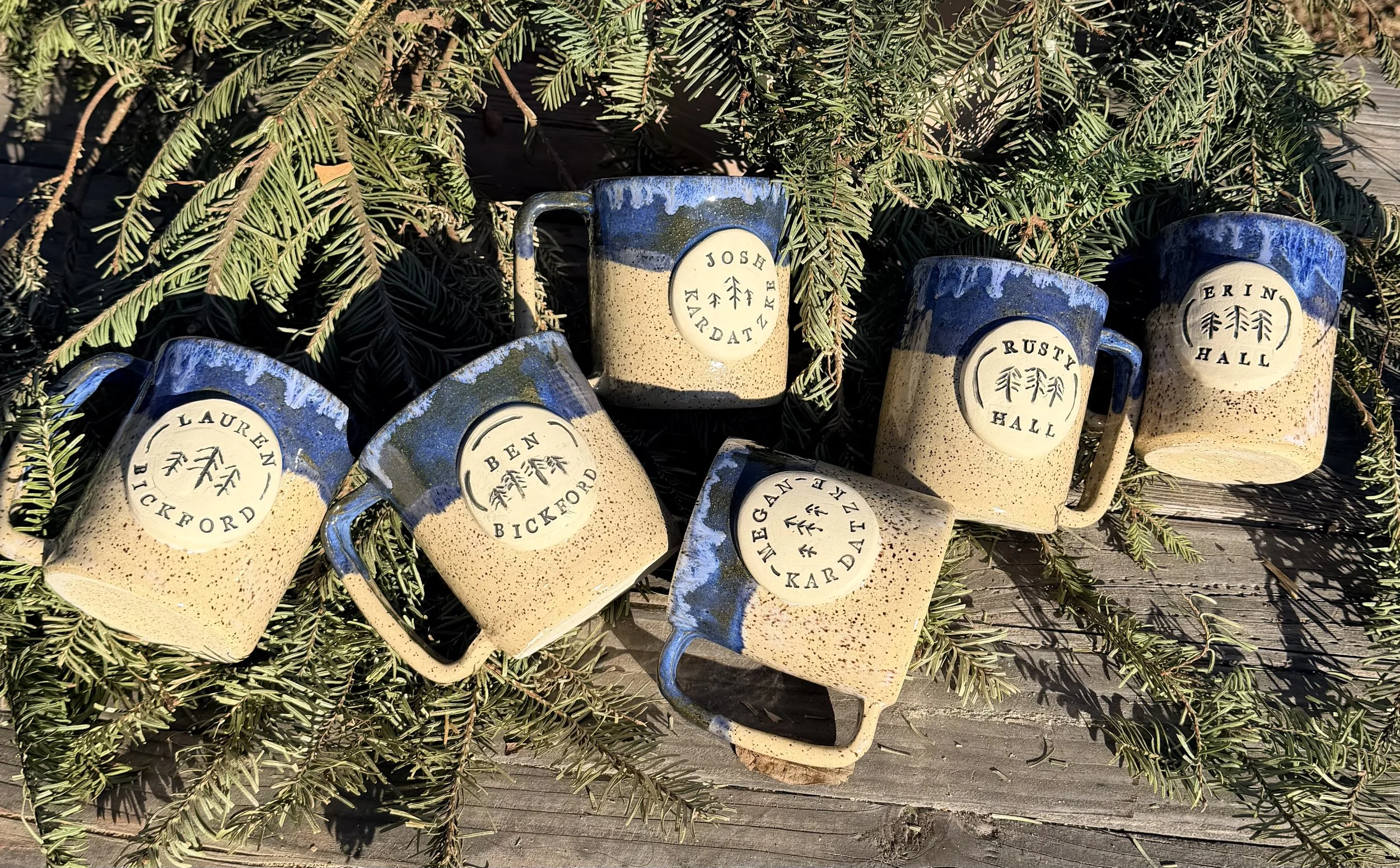 Set of 5 Blue and tan speckled coffee mugs with. custom name stamps and pine tree carving
