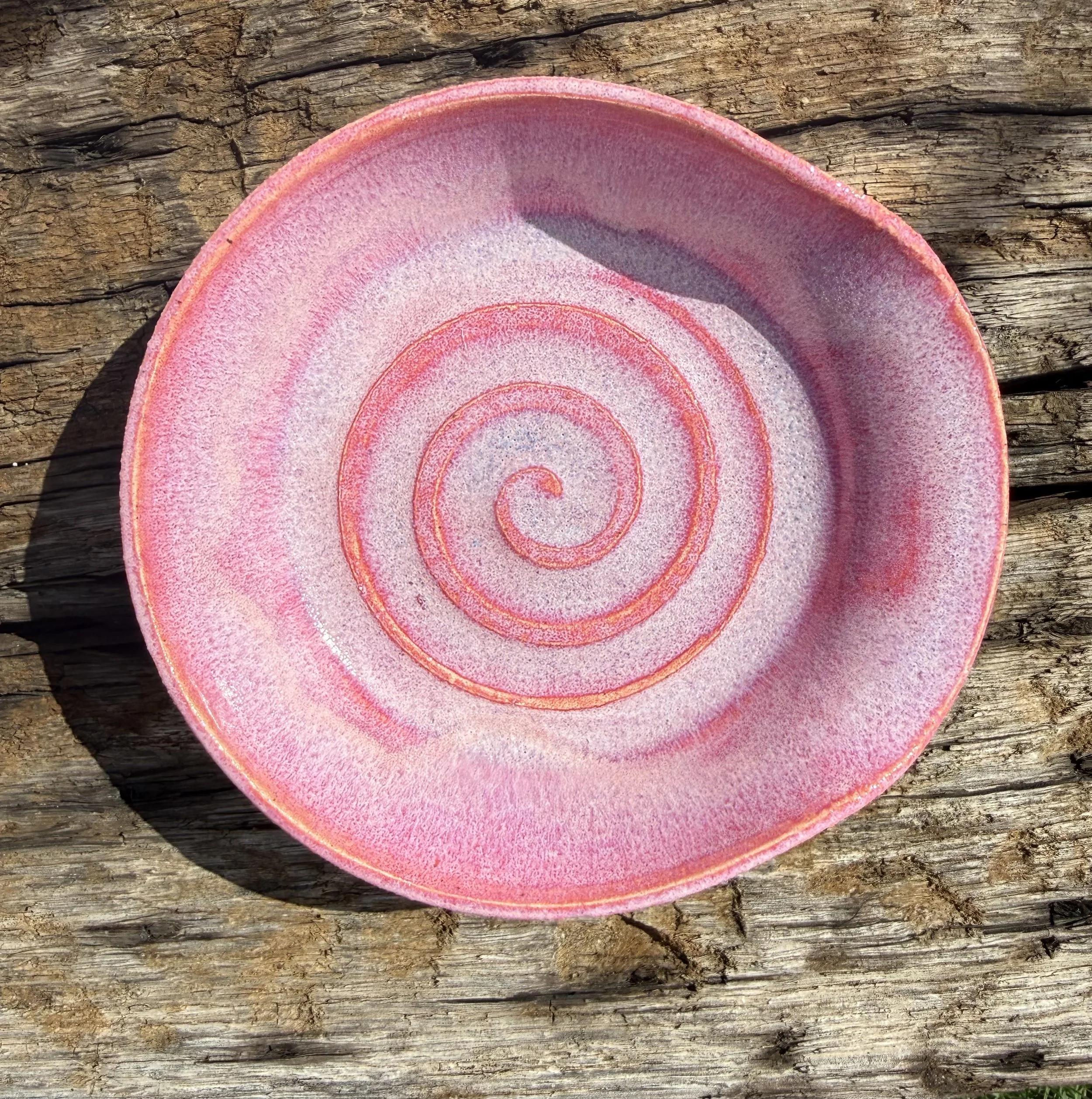 Pink ceramic plate with a swirly design