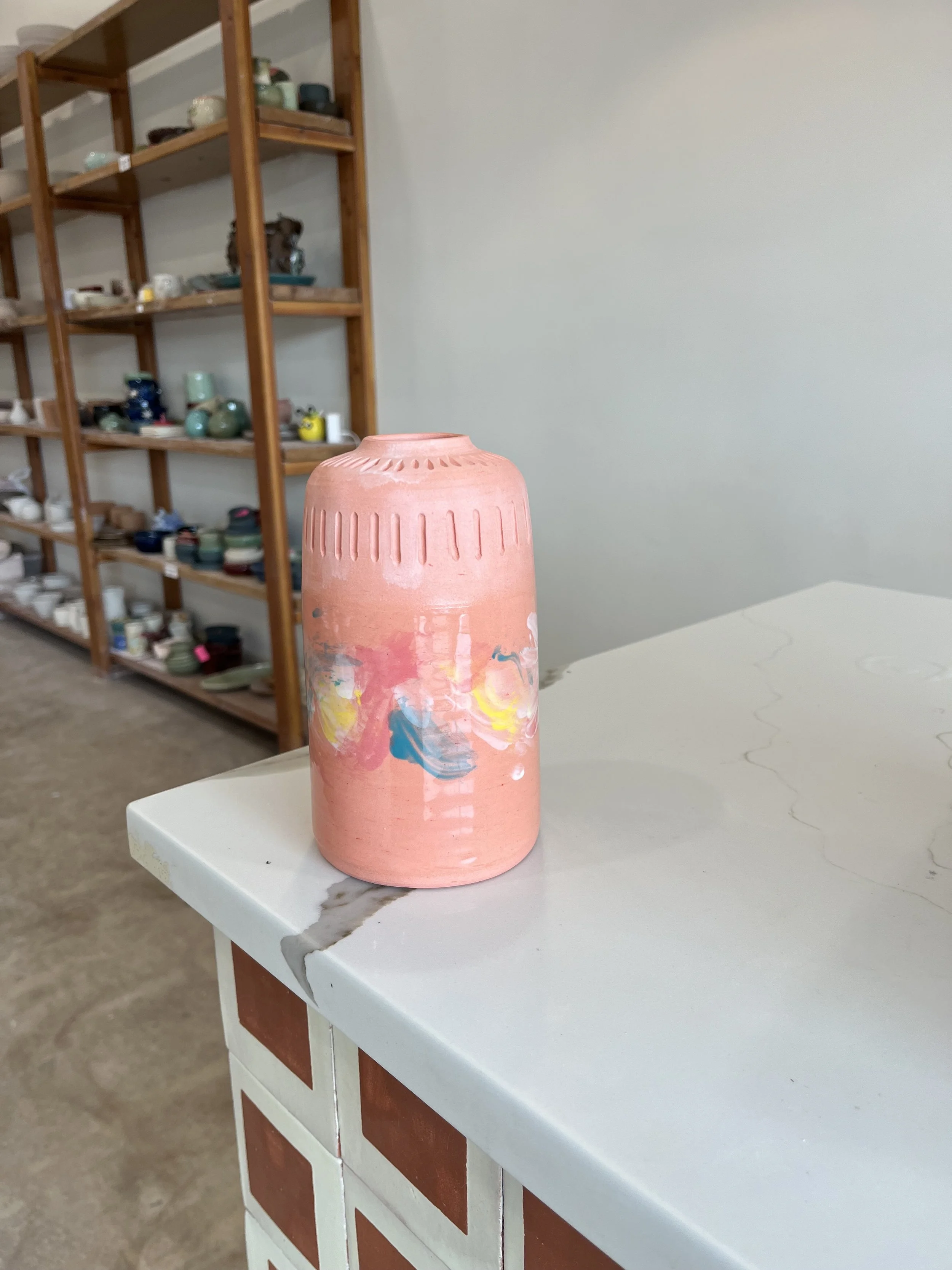 Hand carved pink vase with pink, white yellow and blue design