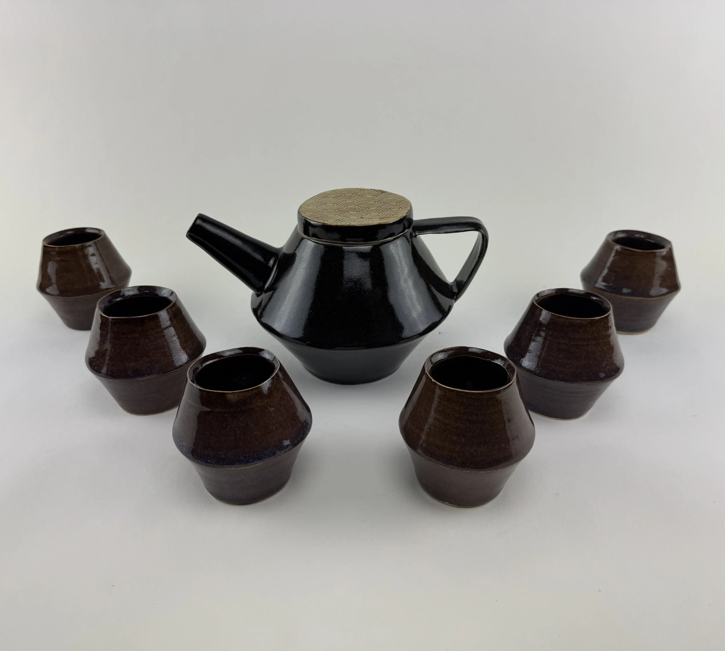 A set of one black teapot and 6 brown teacups