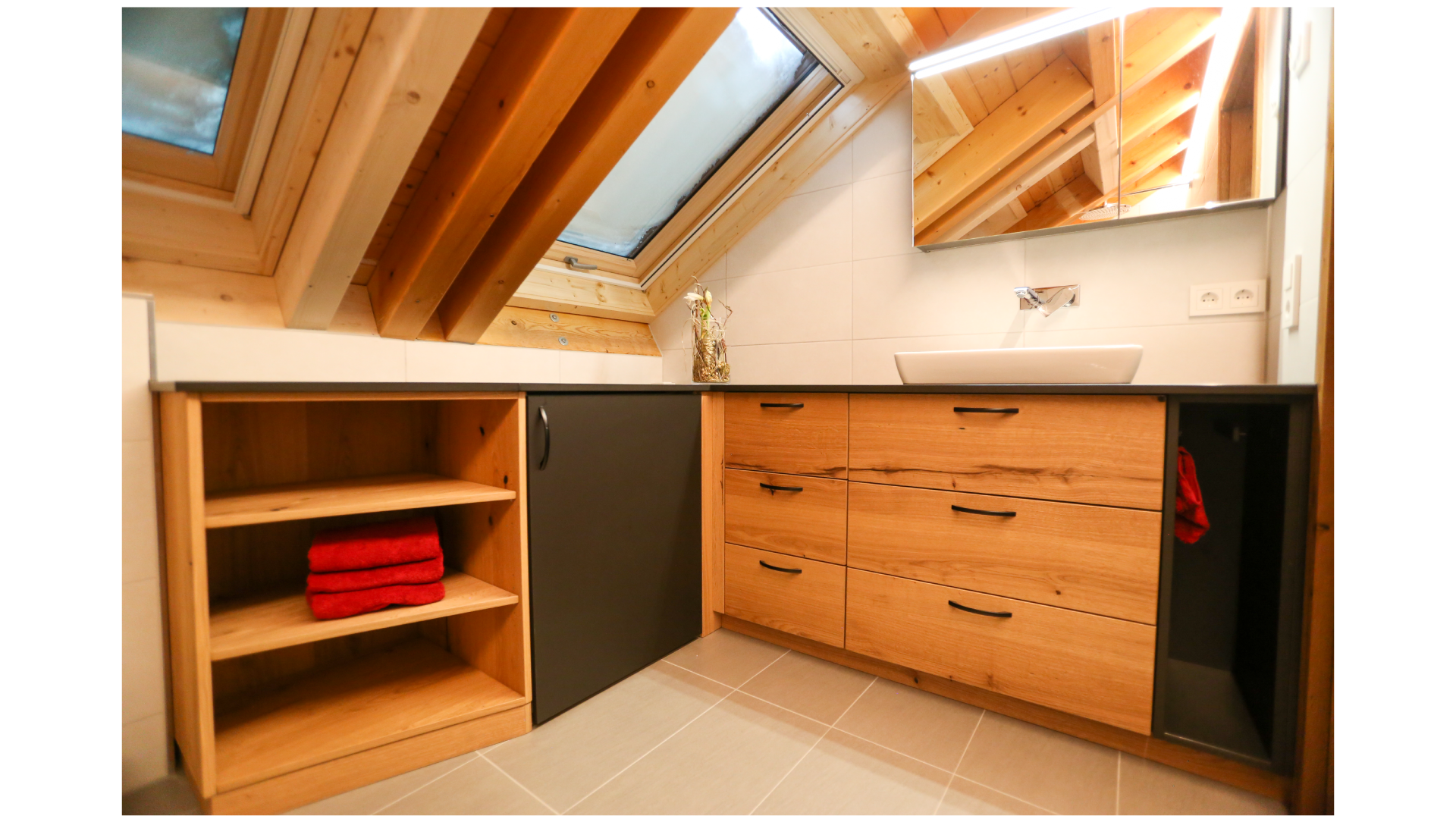 Modernes Badezimmer mit Holzschränken und einem weißen Waschbecken unter einem Dachfenster
