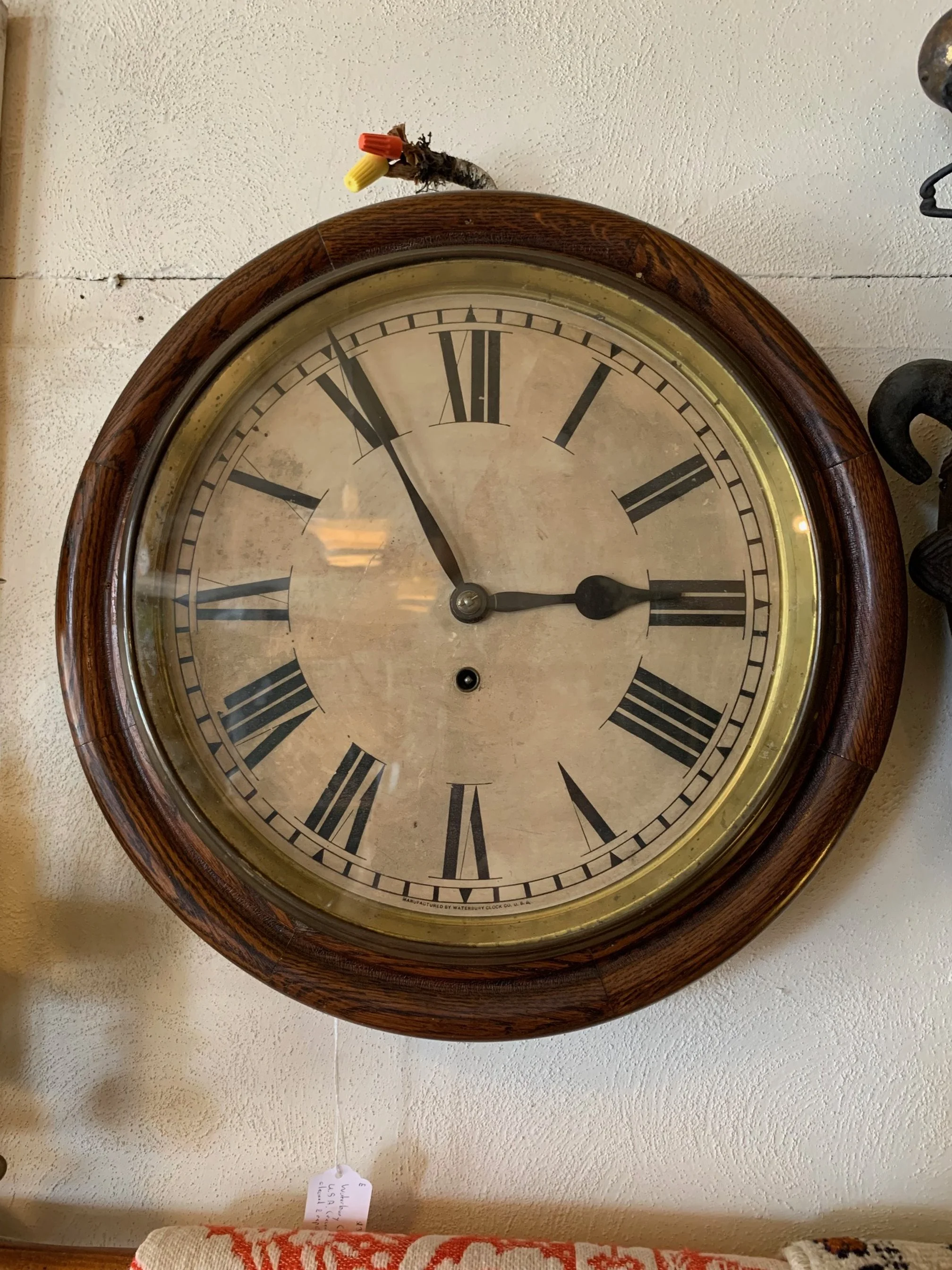 A vintage wall clock with a wooden frame.