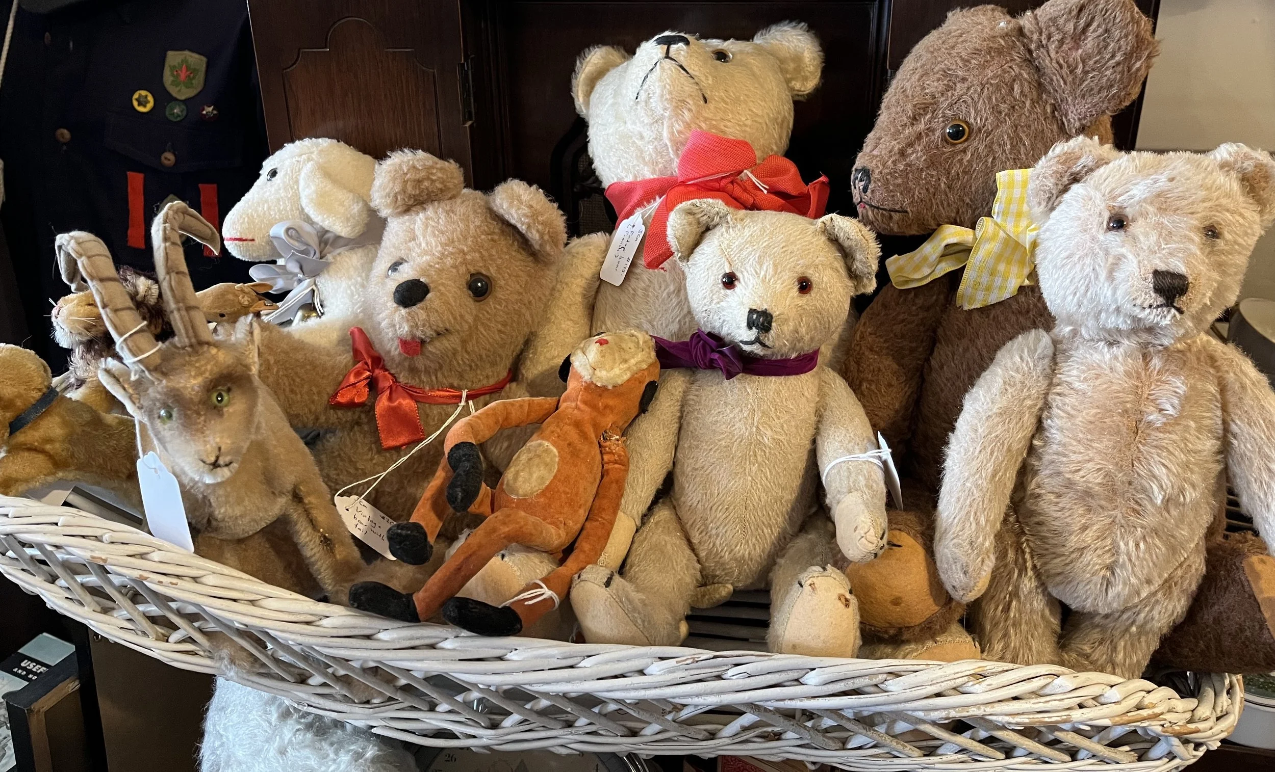 A plush teddy bear sitting on a small skateboard.