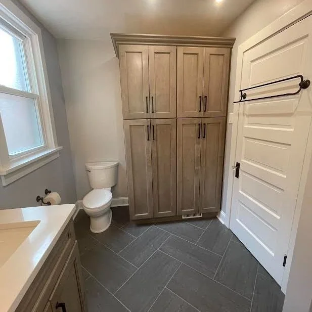 Sewickley Primary Bath featuring new custom linen storage and heated tile floors in a fun, large format herringbone pattern.