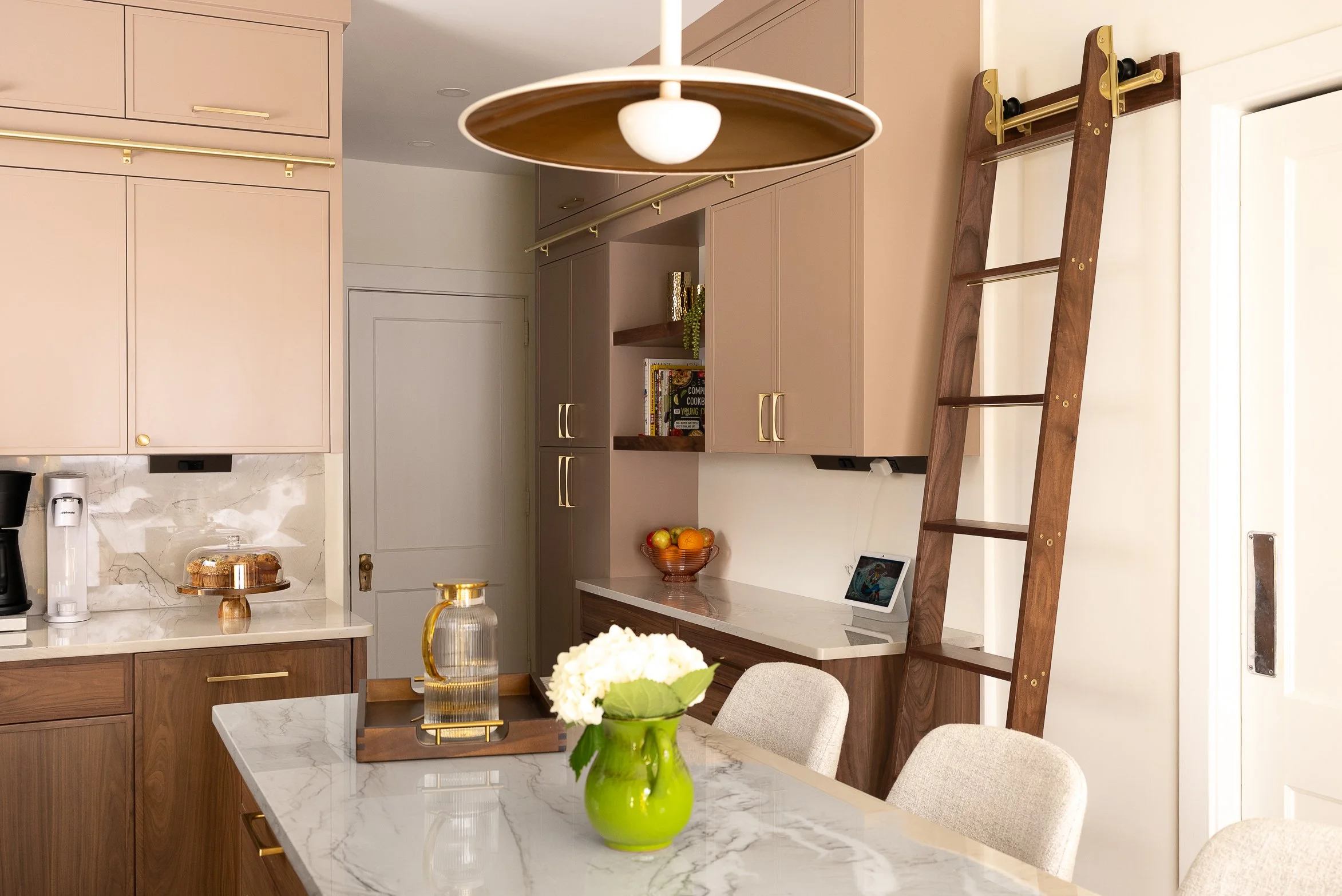 Schenley Farms Residence - Custom walnut base cabinets, painted uppers, brass hardware and a walnut ladder to reach every item with ease. Photo by KH Home Photos