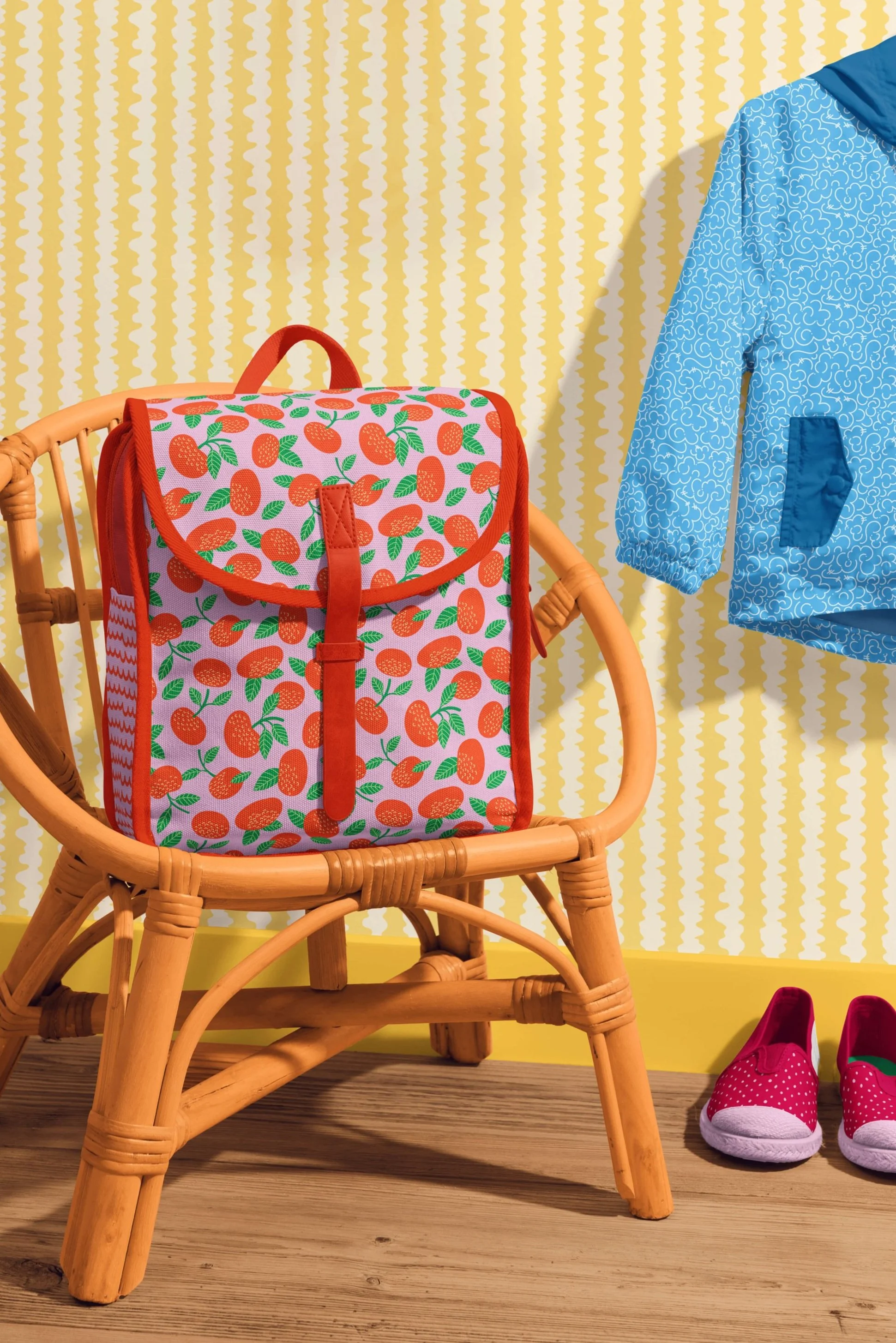 Children’s backpack featuring Tangerine Bounce and Rind, rain shell in Puffs, shoes featuring the Seeds pattern, and wall paper in Ziggy Lanes—all from the Zoomy Fruits collection.