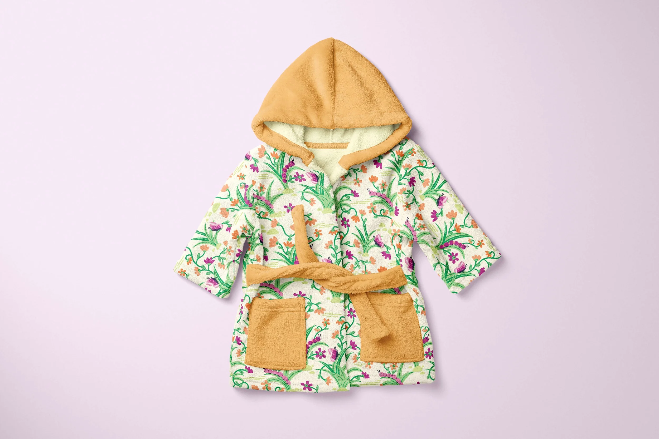 A plush baby or toddler bathrobe with a garden-inspired pattern with butterflies, caterpillars, and pretty flowering vines.