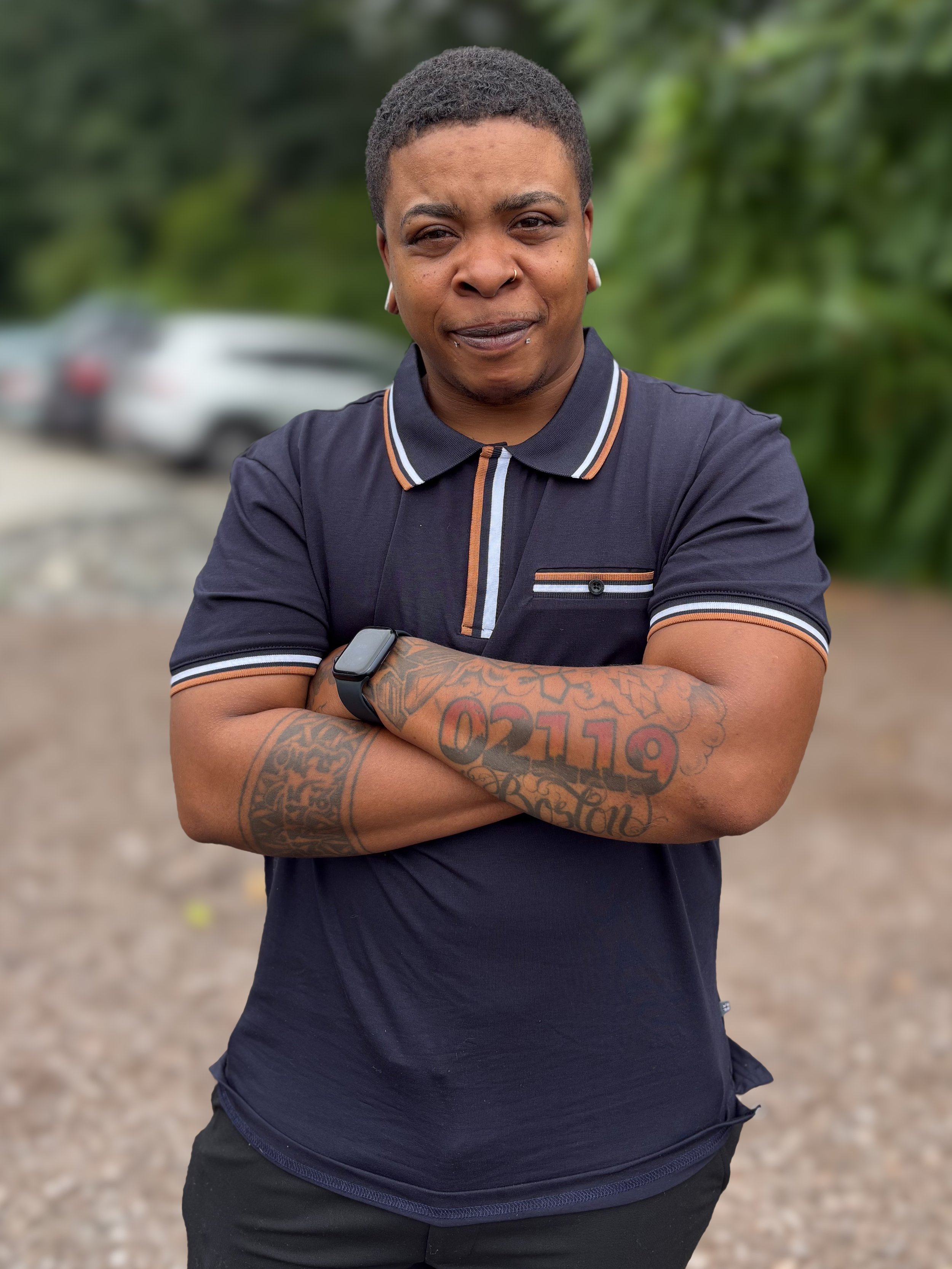 Black and white photo of a smiling person with piercings