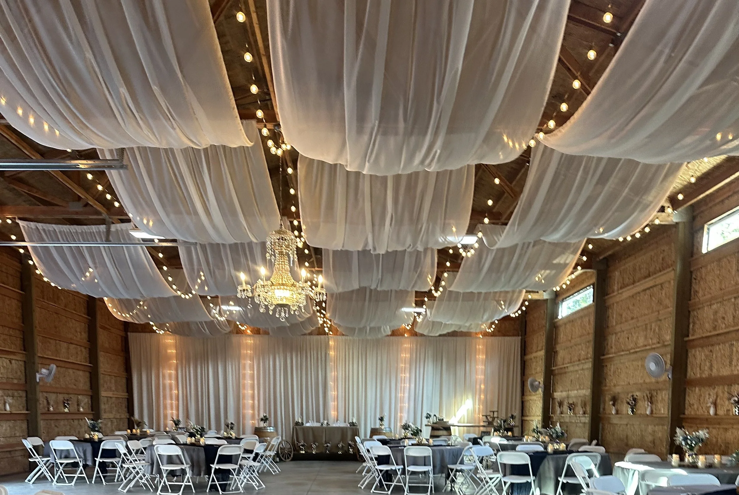 Crystal Chandelier wedding venue with whites drapes on the ceiling