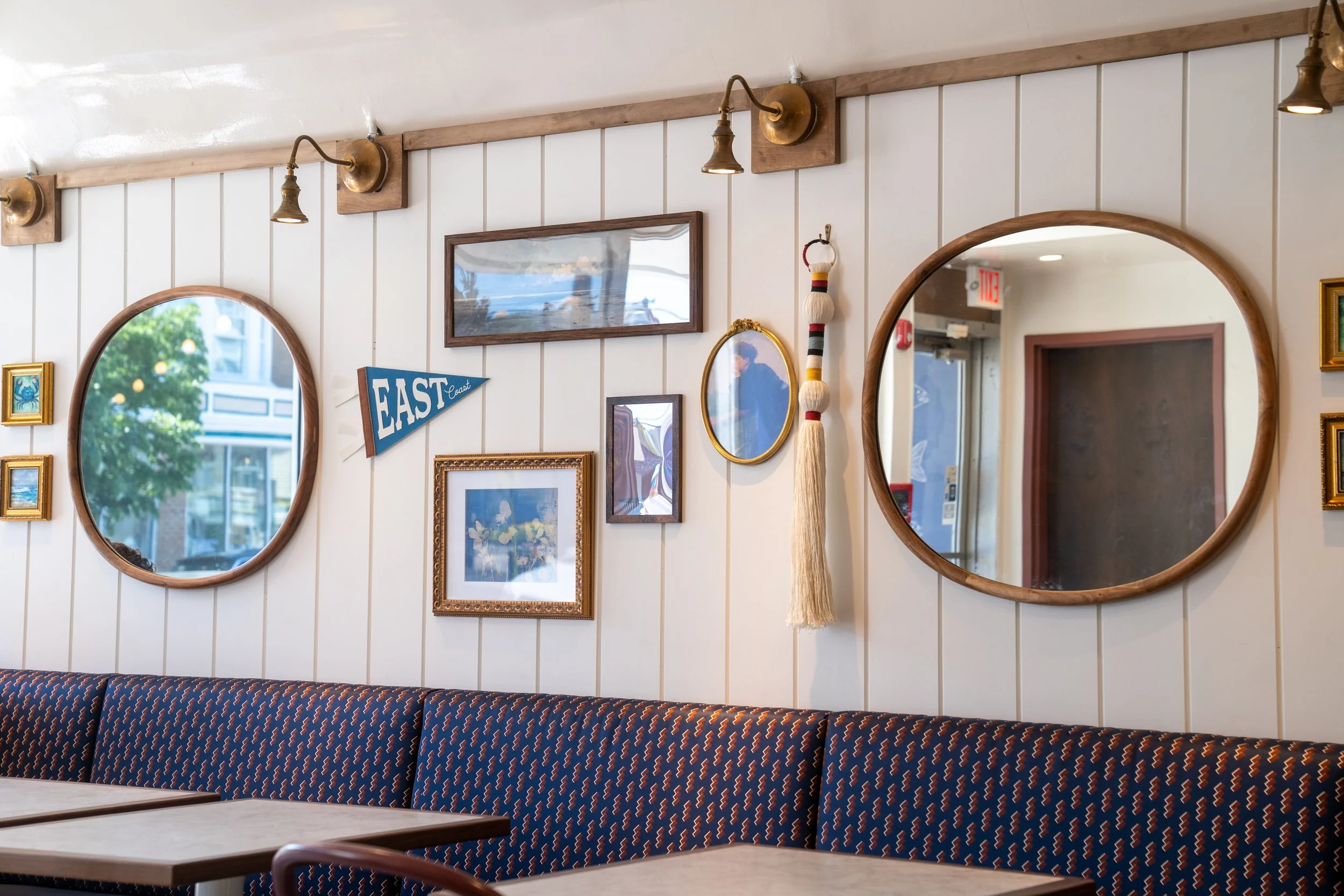 mirrors, pictures, and decor hanging from a wall inside of landmark cafe
