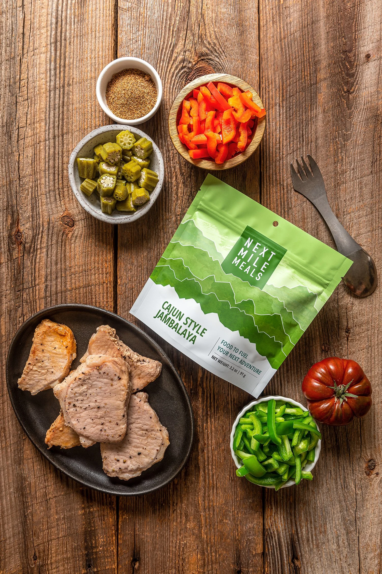 Food photography of premium freeze-dried trail food for hiking. Artistically composed from a bird's-eye view to highlight wholesome, low-carb ingredients and fresh dehydrated meal prep on a rustic wood cabin table.