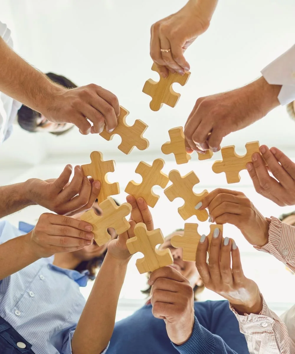 staff members holding puzzle pieces