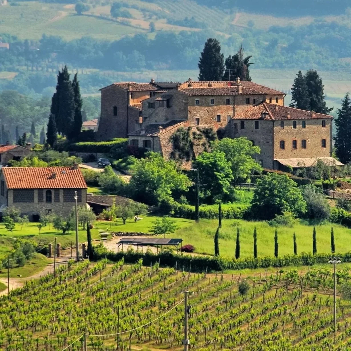 Italian winery set among rolling vineyards and historic stone buildings in the countryside