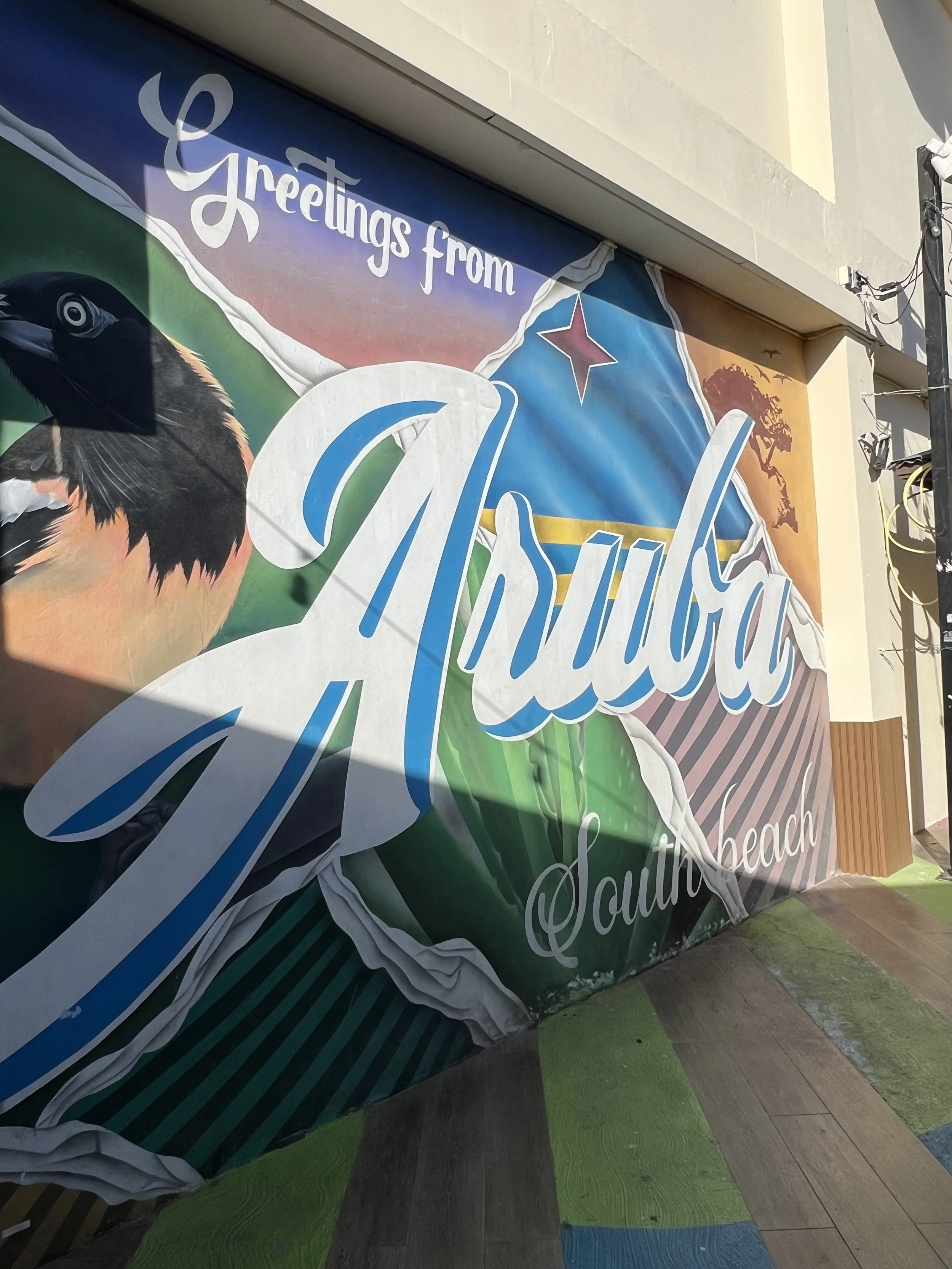 Colorful “Greetings from Aruba” postcard-style mural