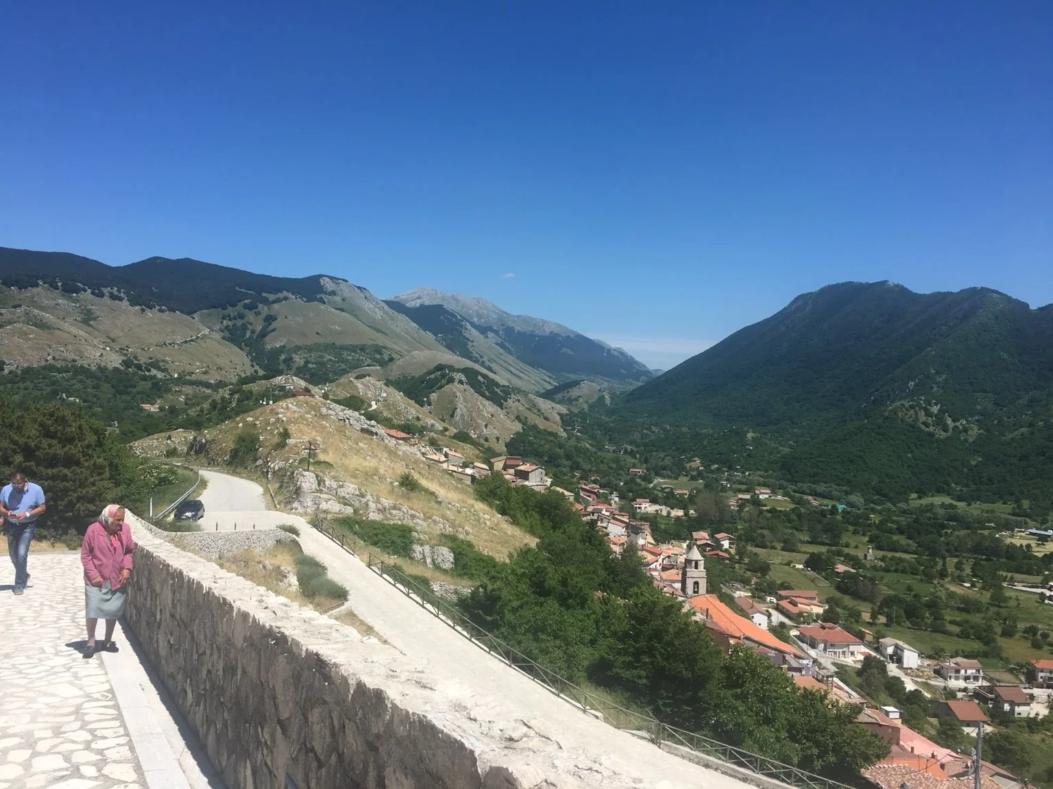Mountain village with a church and hillside road photographed during Jeanine’s family-roots visit in Italy.
