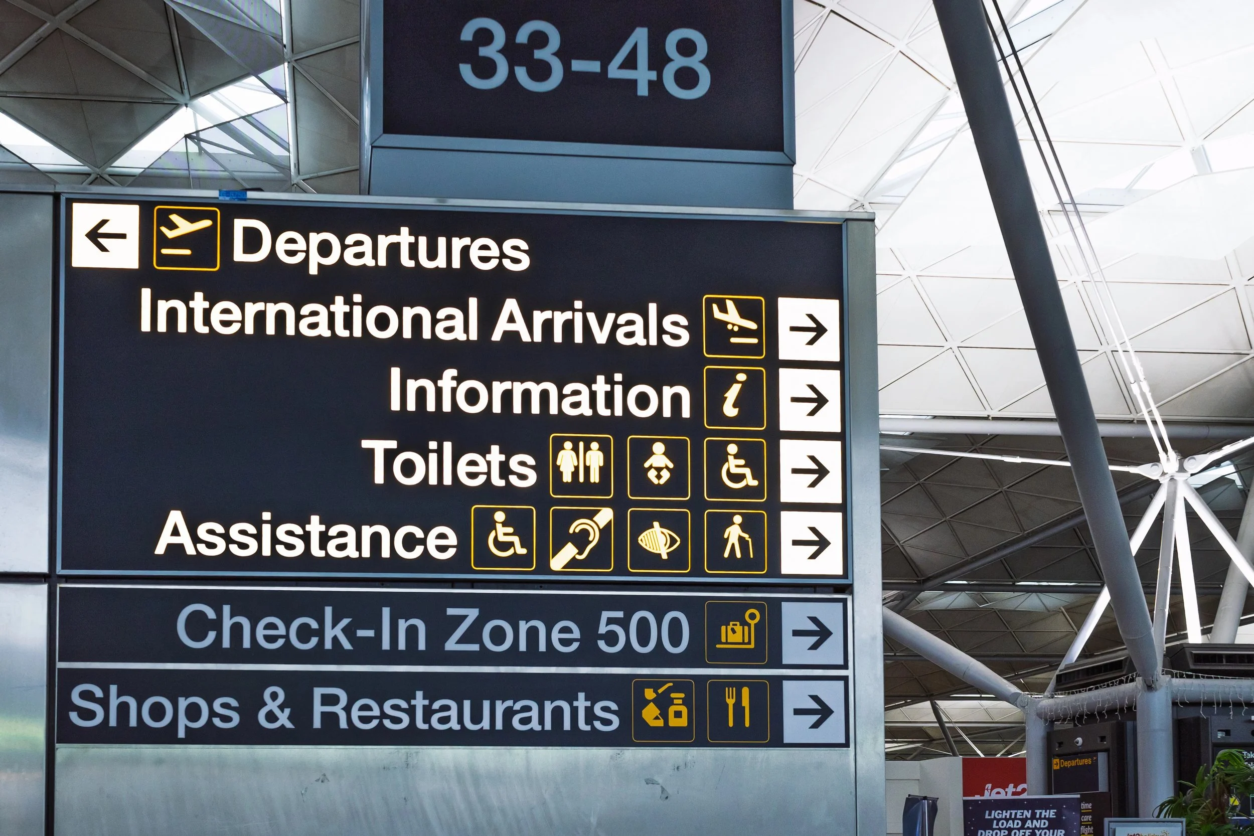 Close-up of an airport international departures and arrivals board, highlighting professional travel management and concierge services.
