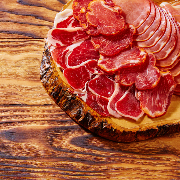 Thinly sliced Ibérico ham on a wooden board