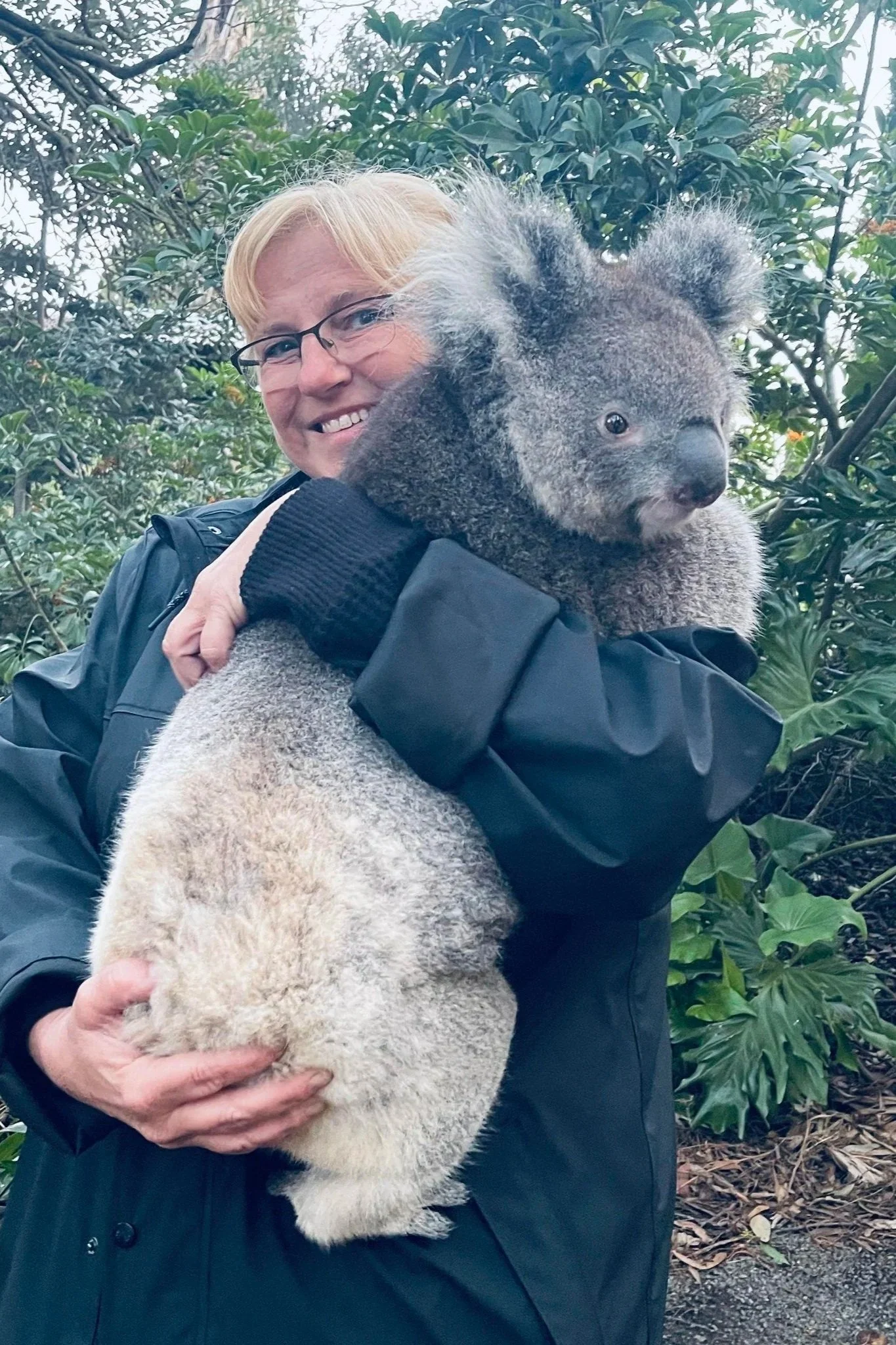 Travel specialist, Jeanine, holding a koala in Australia, highlighting wildlife-focused luxury travel experiences.