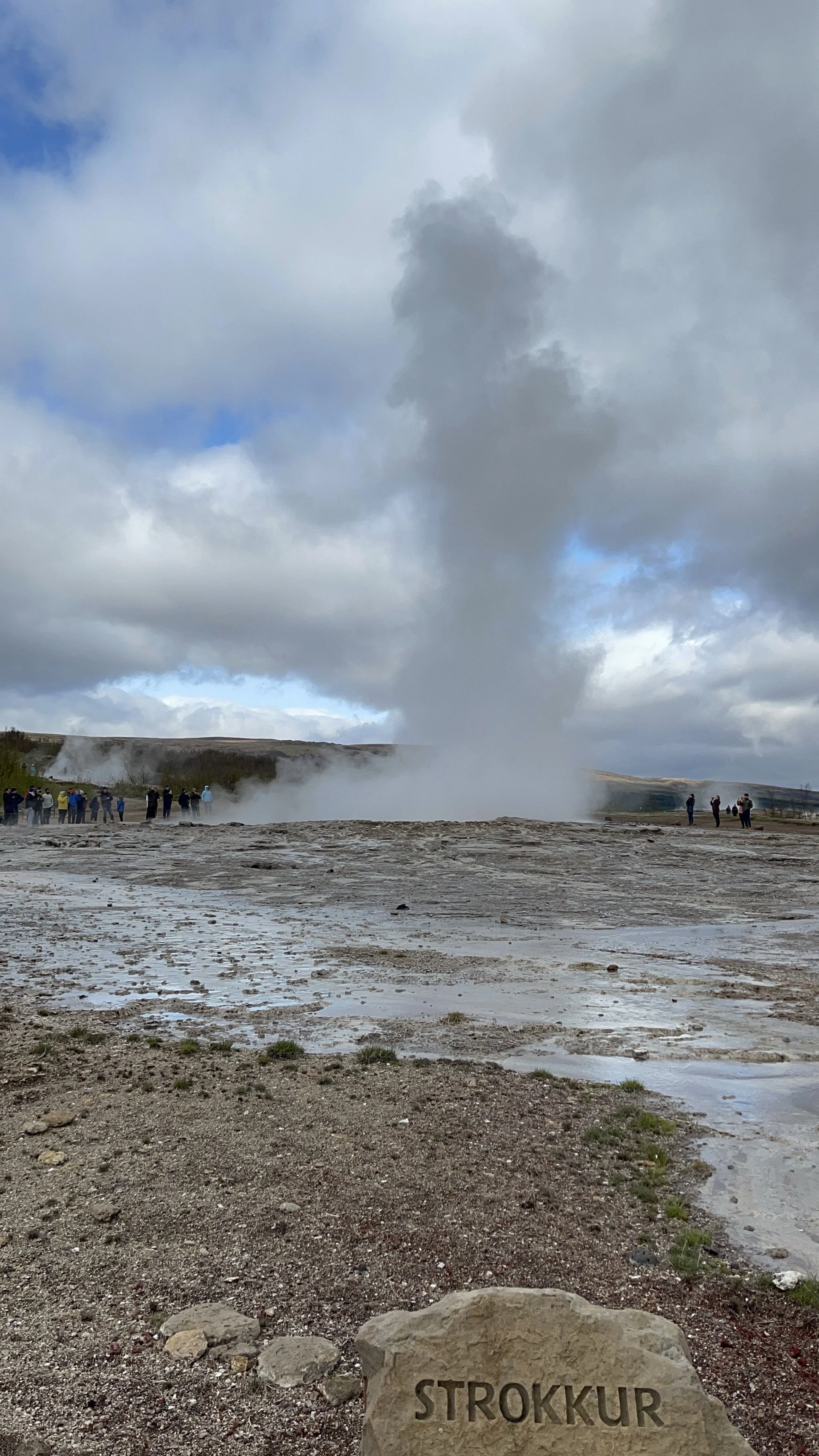 Geyser erupting beneath a cloudy sky during Jeanine’s Iceland trip