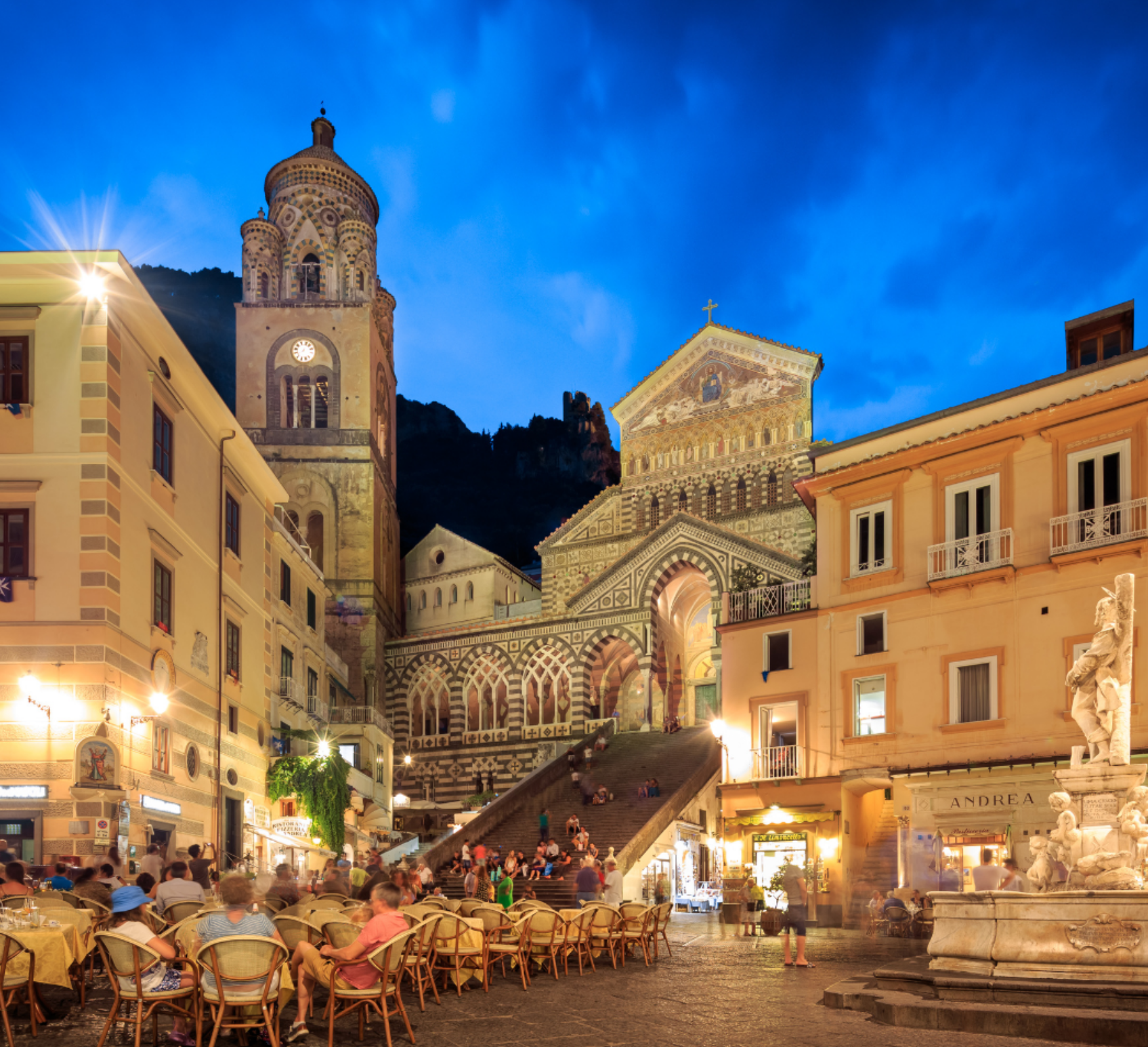 Evening scene in Ravello’s Piazza Duomo, Italy, featuring the historic cathedral, outdoor dining, and lively crowds during the Ravello Music and Arts Festival on the Amalfi Coast.