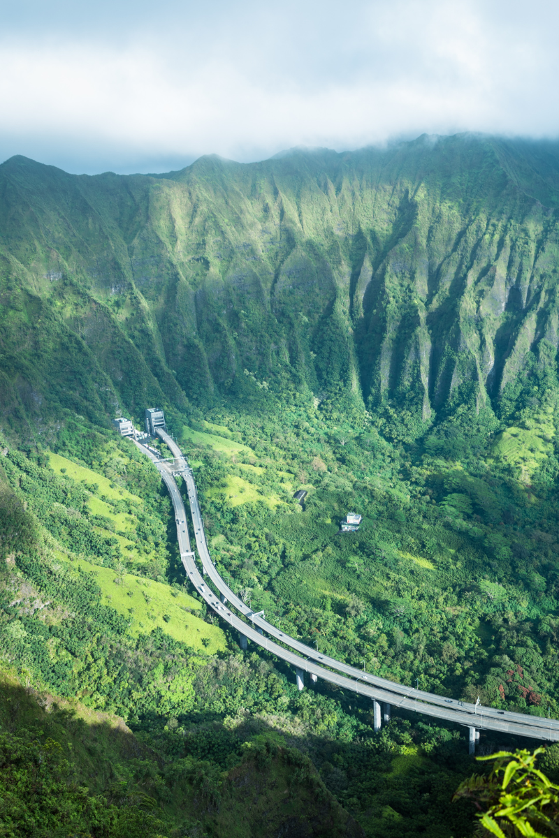 Take in the iconic, breathtaking view from Oahu’s famous Haiku Stairs (Stairway to Heaven), looking down at the H-3 highway winding through the Koʻolau Range.
