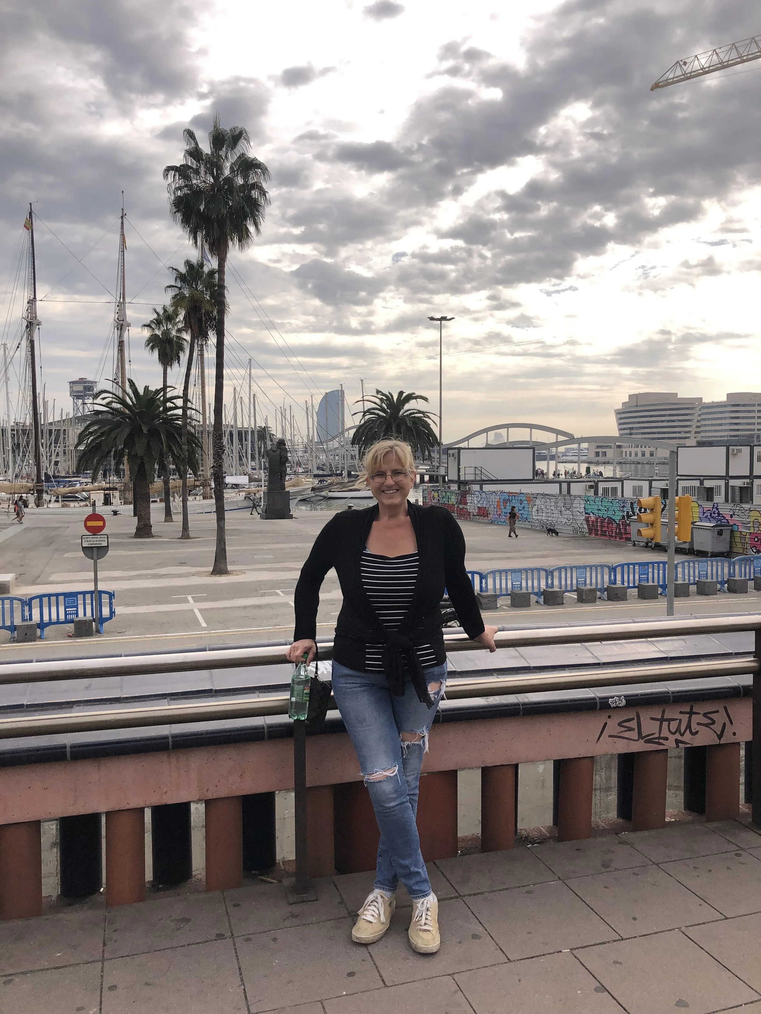 Jeanine Solo Trip to Spain admiring the yachts and beach in Barcelona