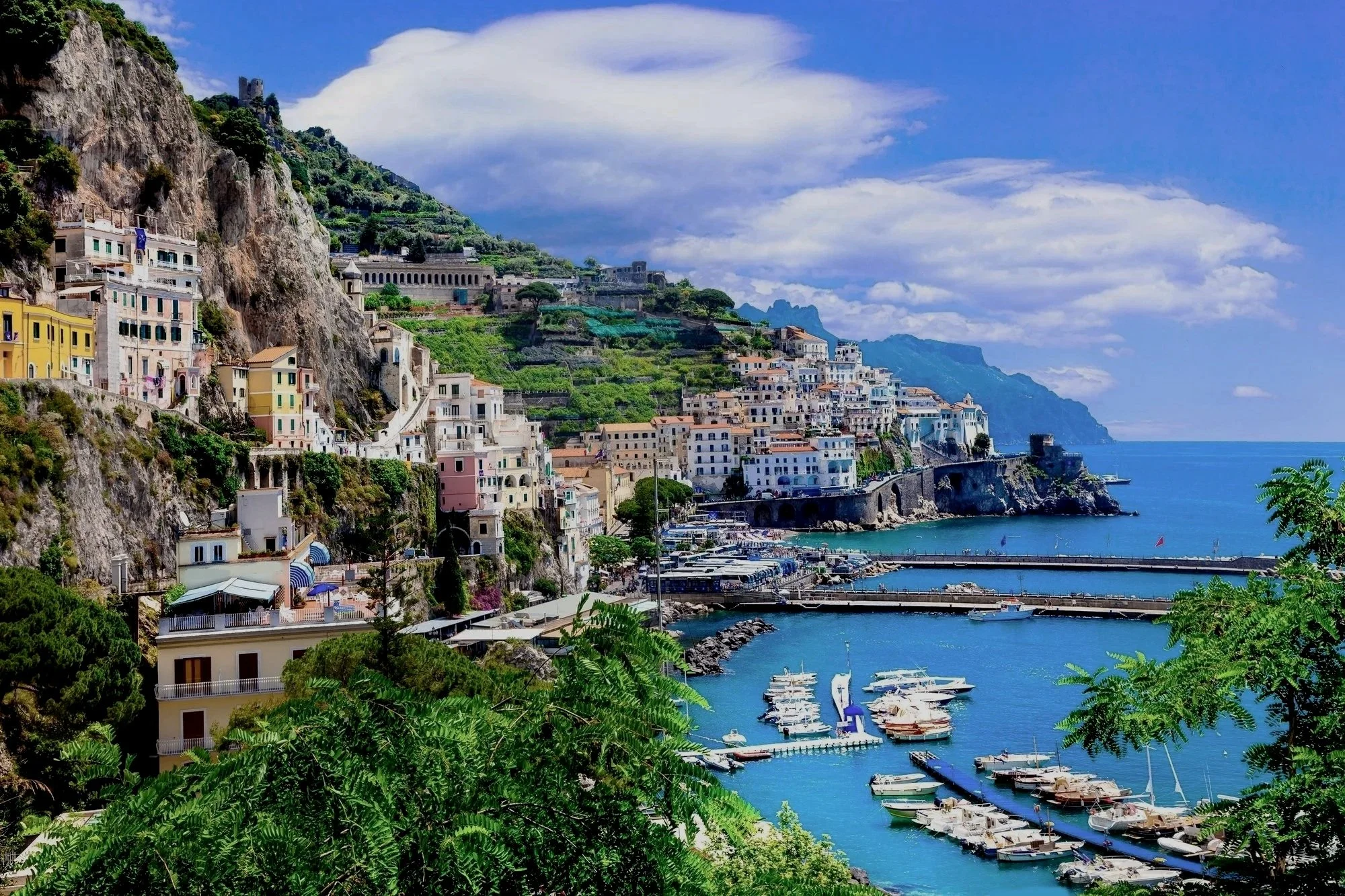 Colorful cliffside villages along Italy's Amalfi Coast overlooking the Mediterranean Sea, inspiring personalized Italy vacations by Lavishly Travel.