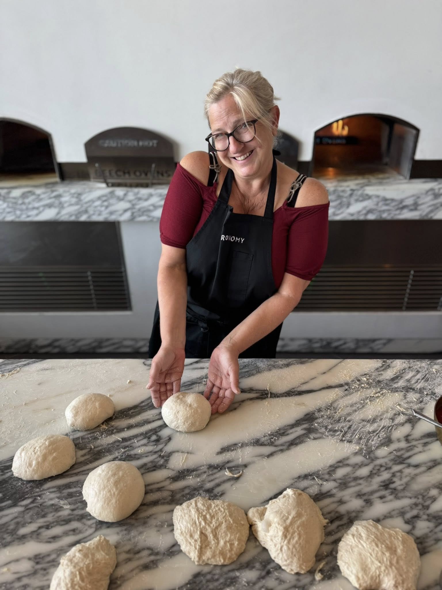 Travel expert, Jeanine, participating in a hands-on pizza-making class, demonstrating immersive culinary travel services.