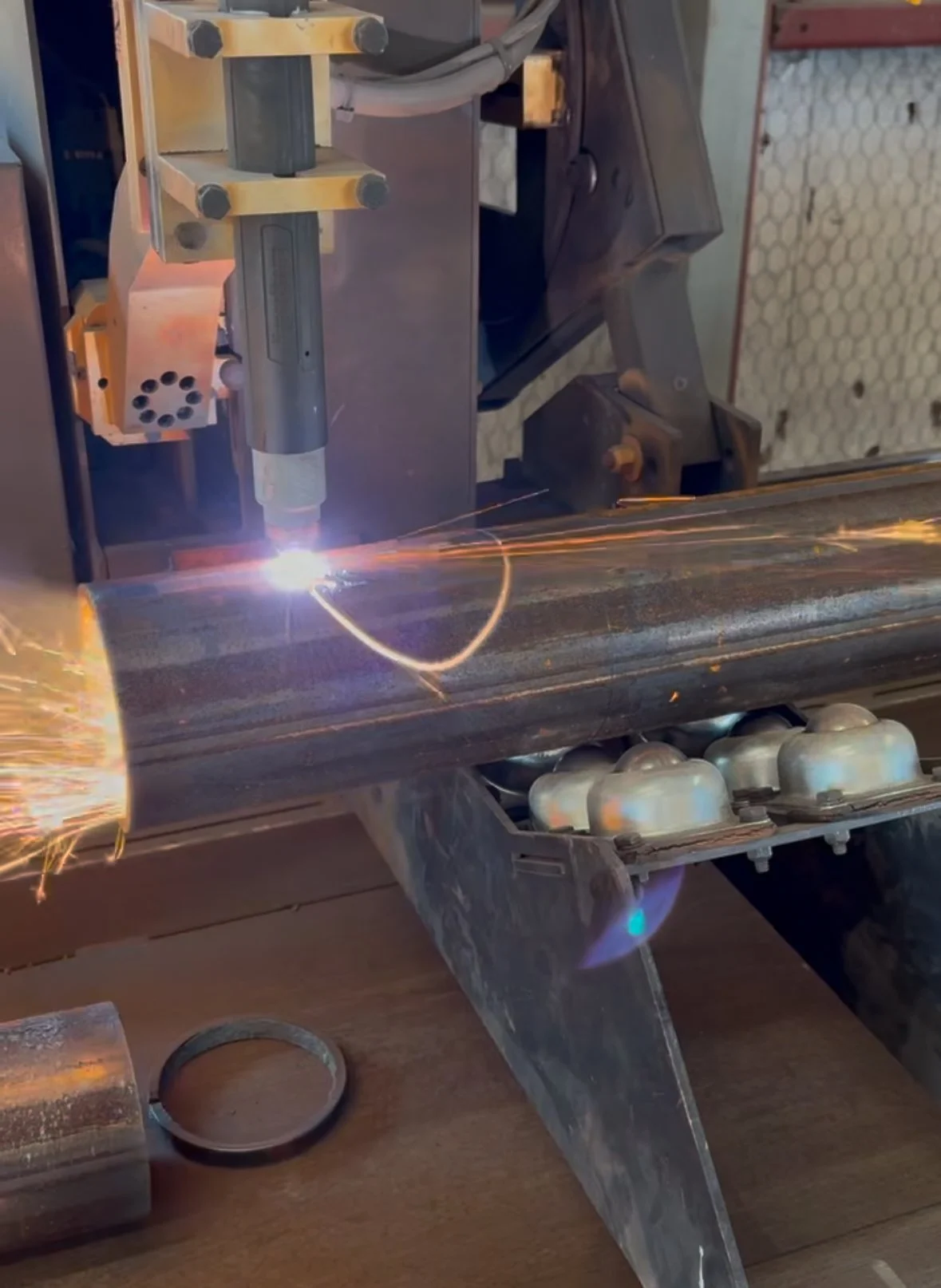 A welding process on a metal pipe, with sparks flying and welding equipment in use.
